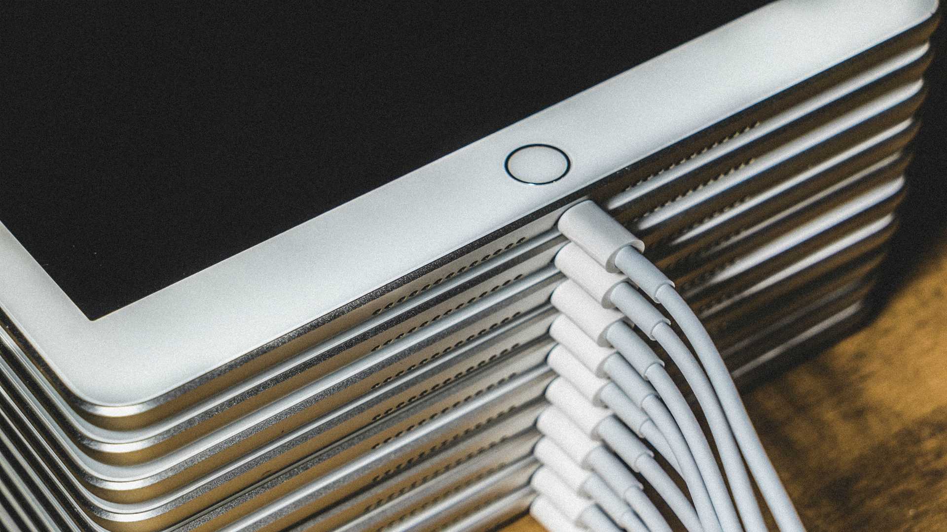 Stack of iPads all plugged in to chargers