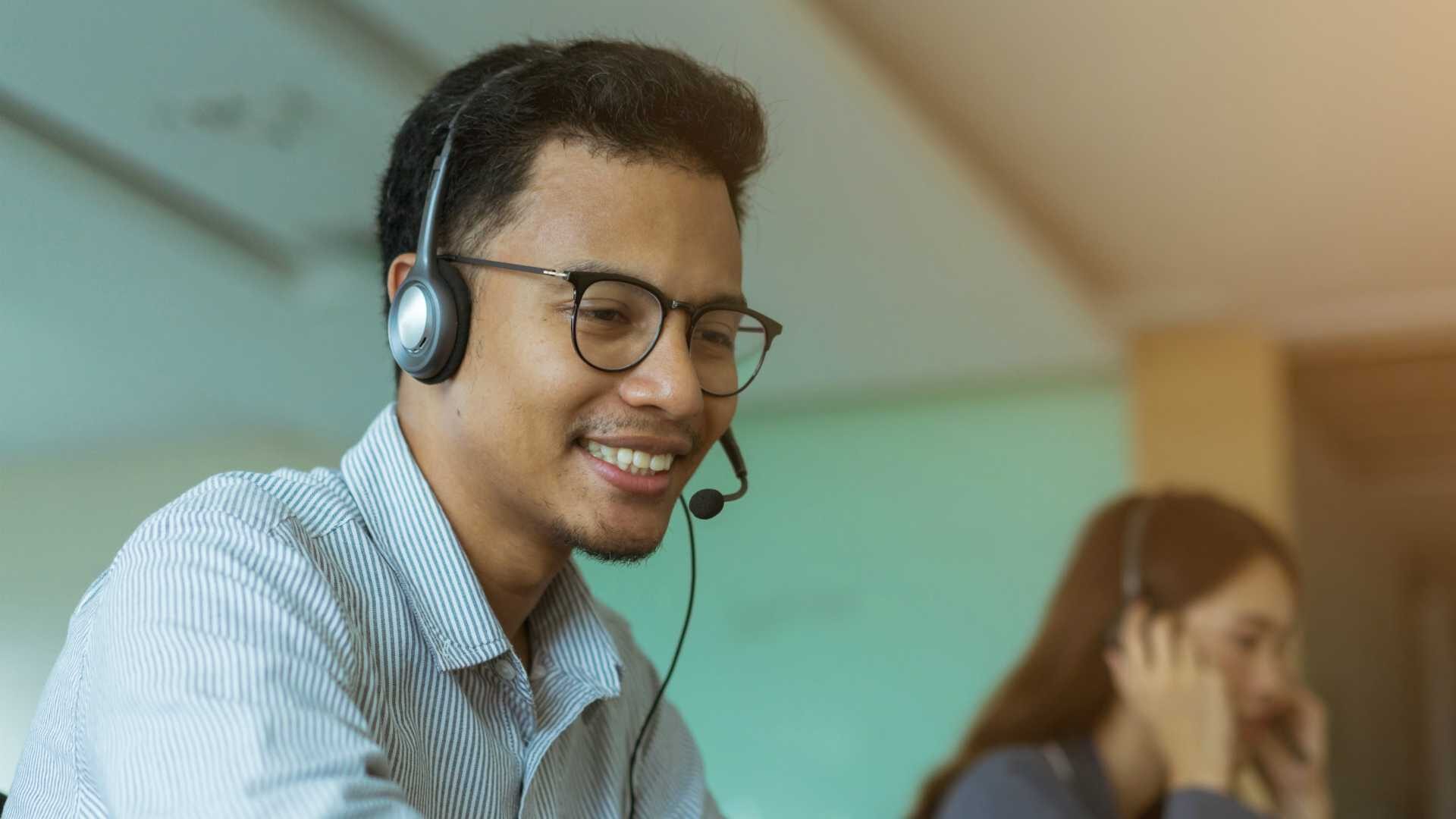 Customer support professional wearing headset providing exceptional customer experience. Employee engagement.