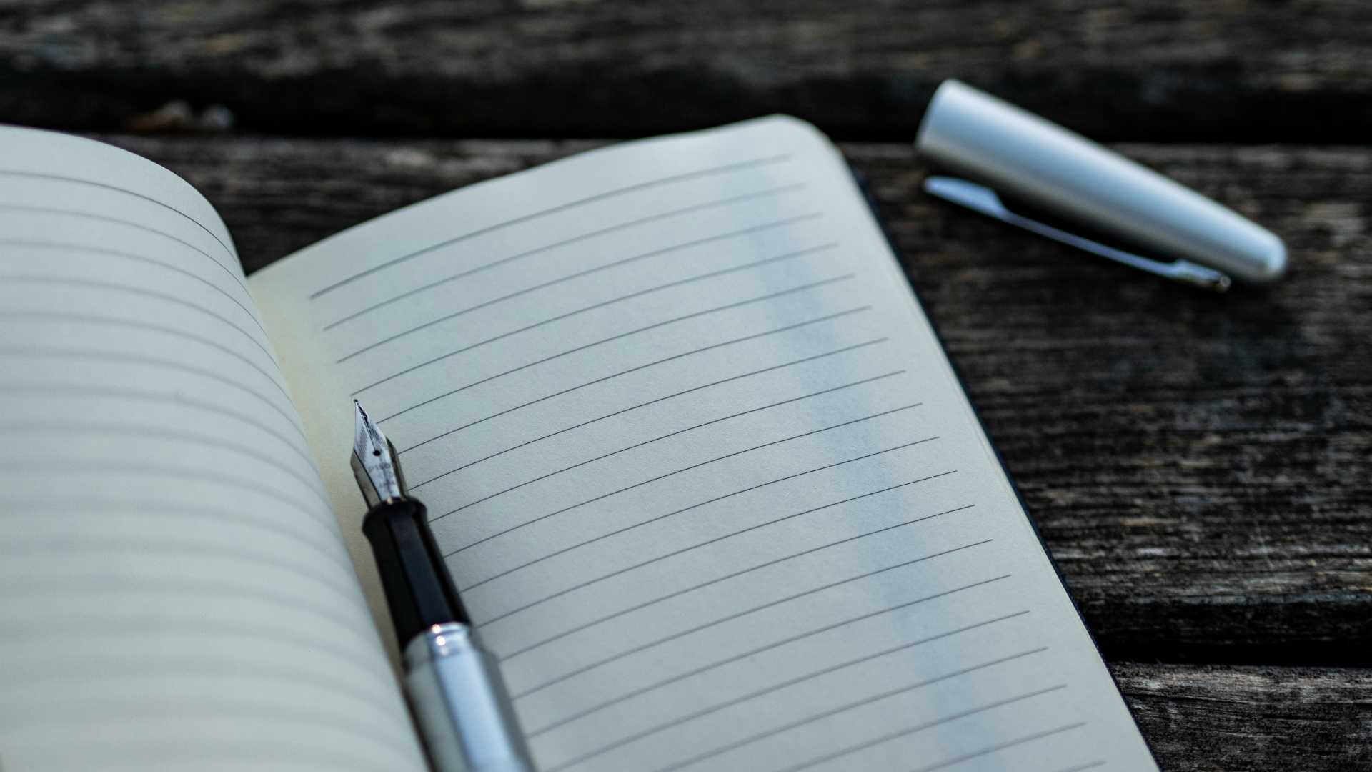 Open notebook with gel pen resting on blank page