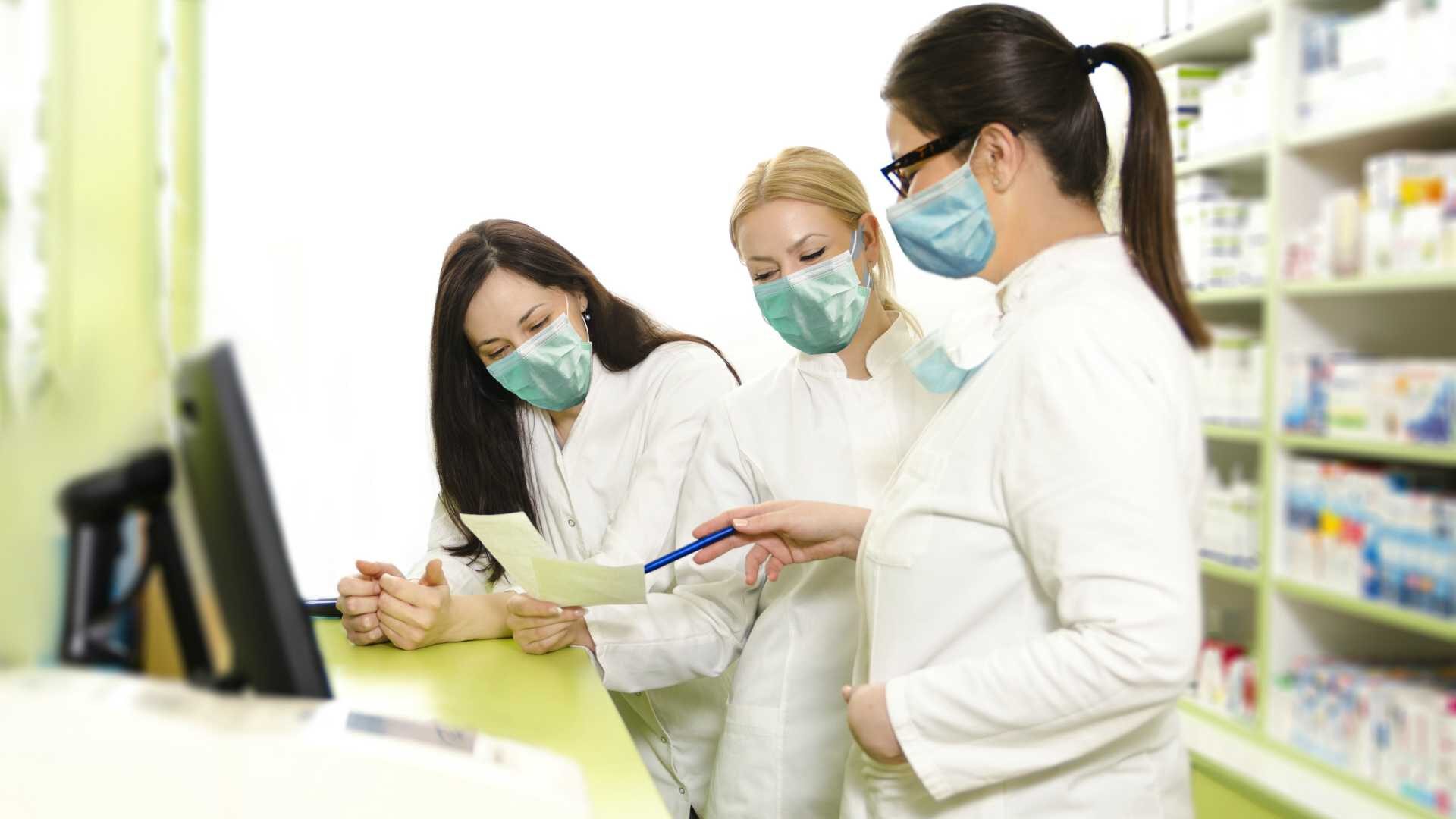 Female retail employees wearing masks in pharmacy setting