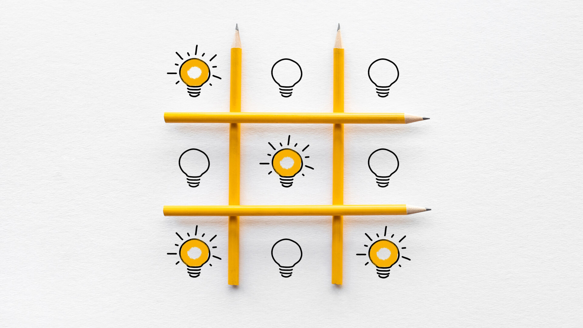 tic-tac-toe board made of pencils, filled in by drawn lightbulbs, some lit, some unlit, showing how great ideas can boost frontline workers
