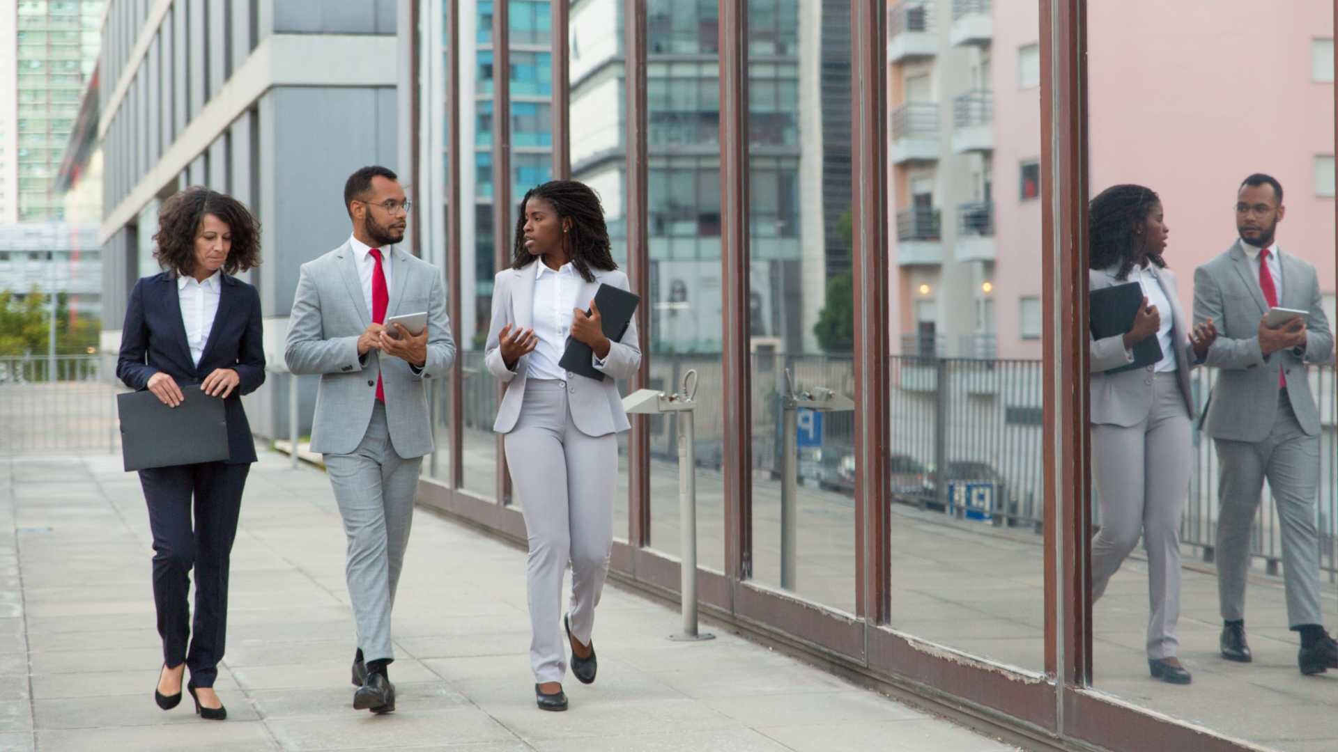 business people of color walk down the sidewalk having a conversation, top sales performers,