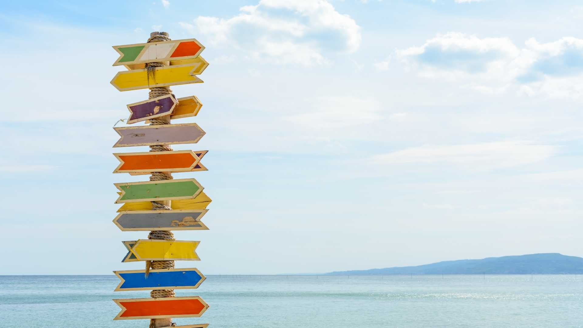 brightly colored signs point in all directions on a beach