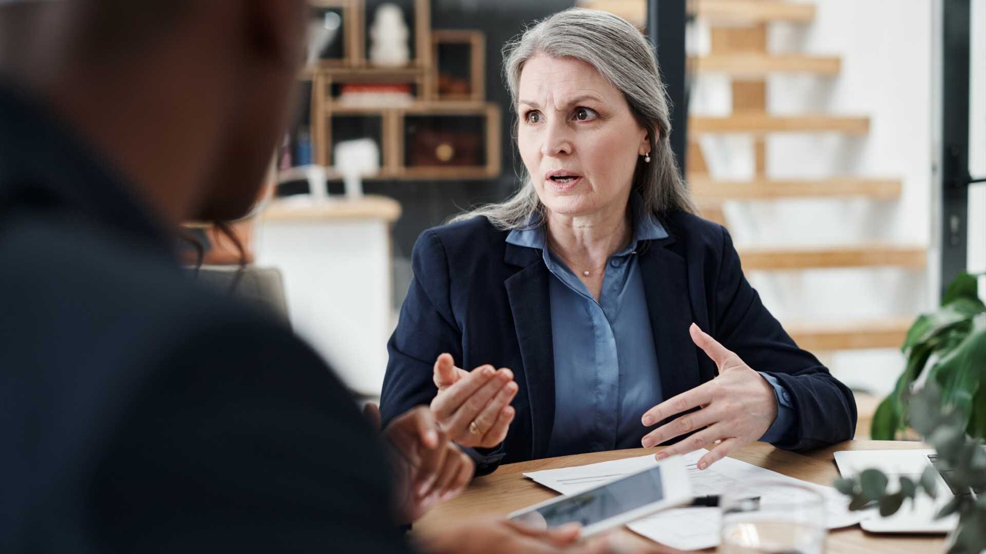 A professional woman engages in a conversation with a colleague.