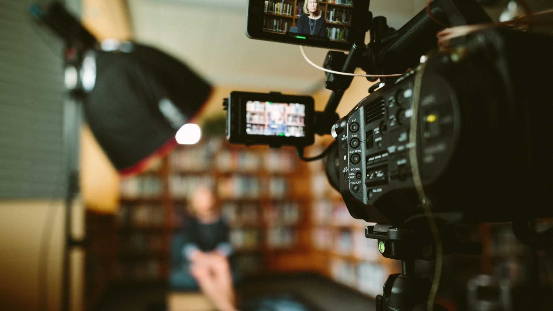 A video camera is recording a person in an interview