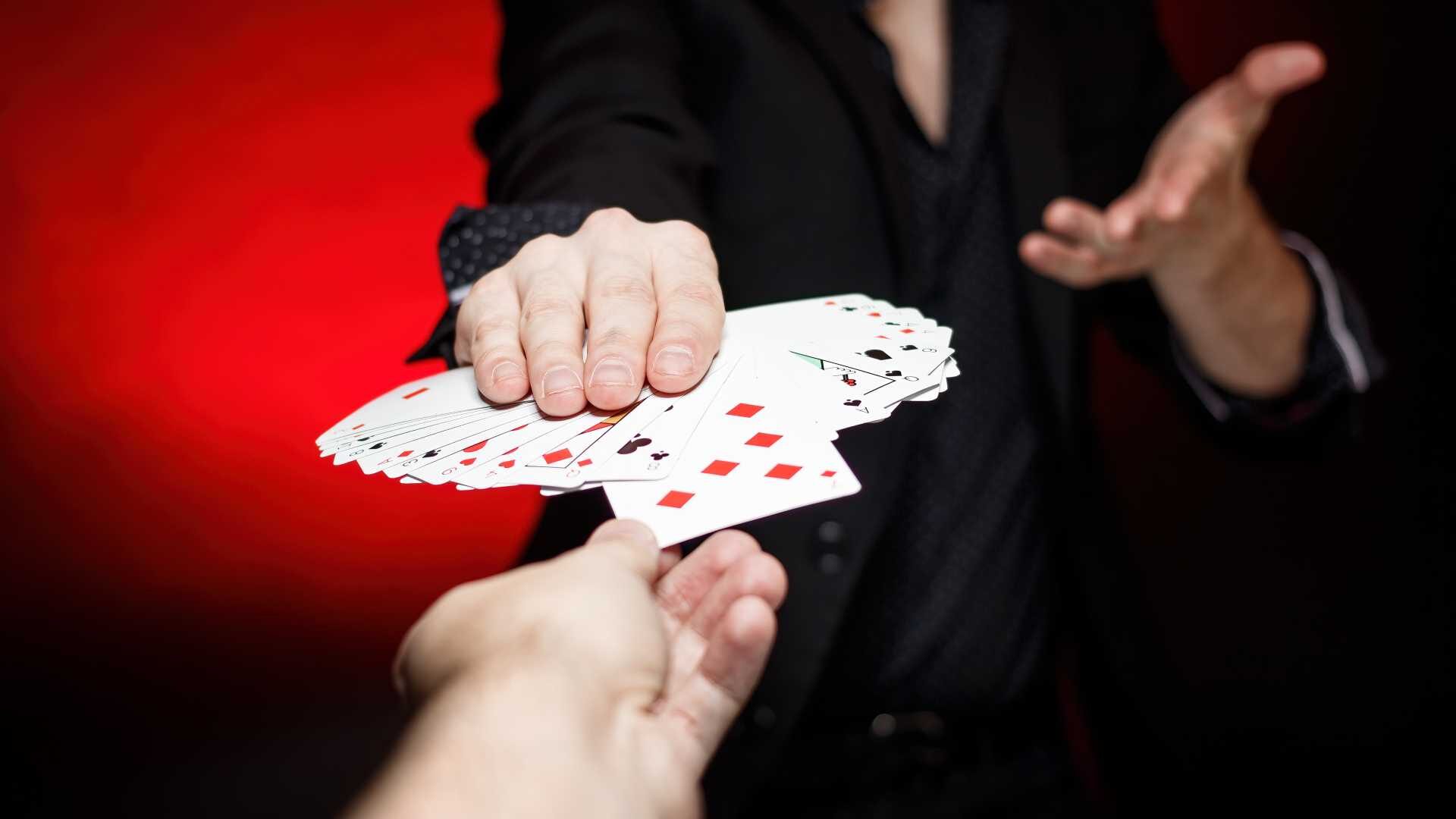 Card dealer shows fanned deck of playing cards.