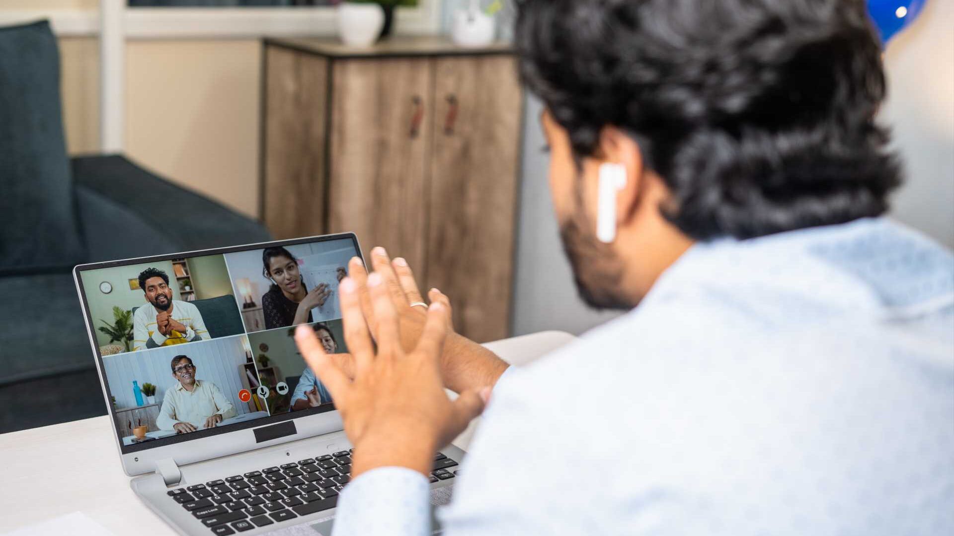 a man attends a virtual meeting with a group of colleagues