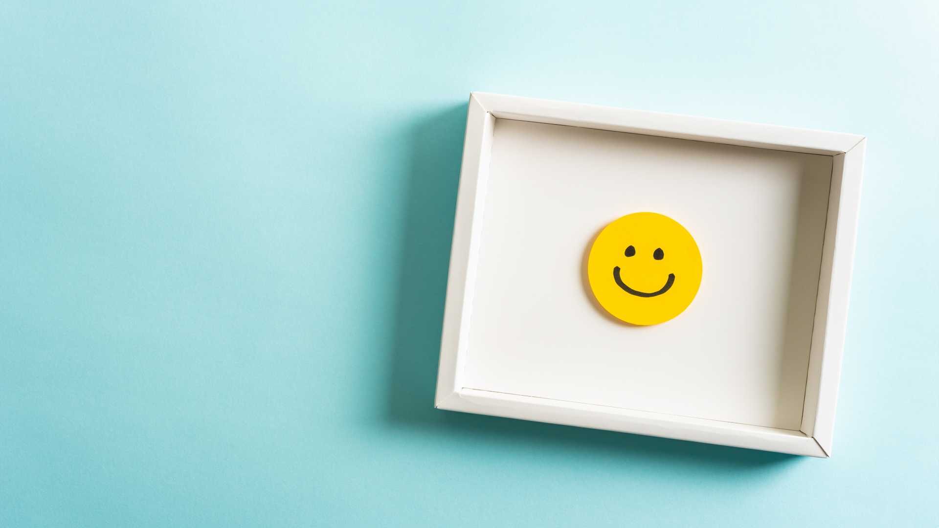 A concept image of a smiling face in a frame against a blue background