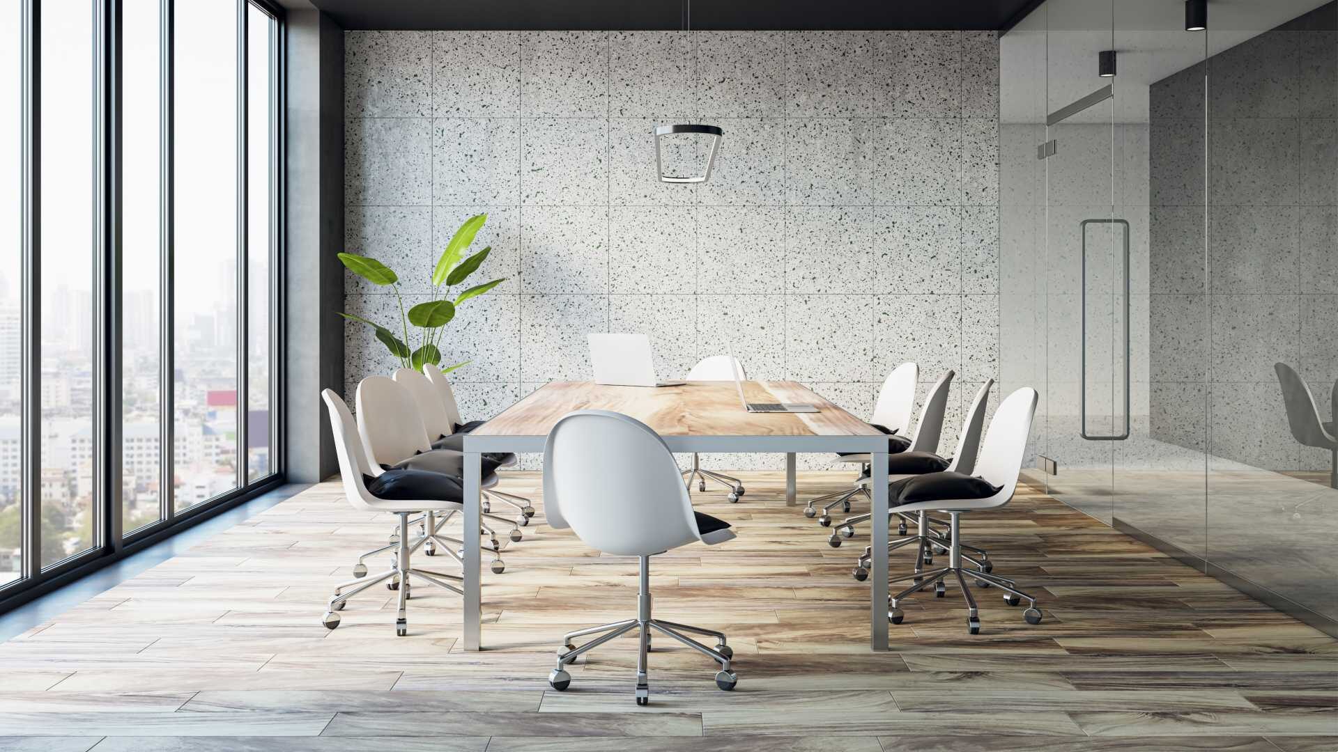 A modern, empty conference room with white chairs and hardwood floors.
