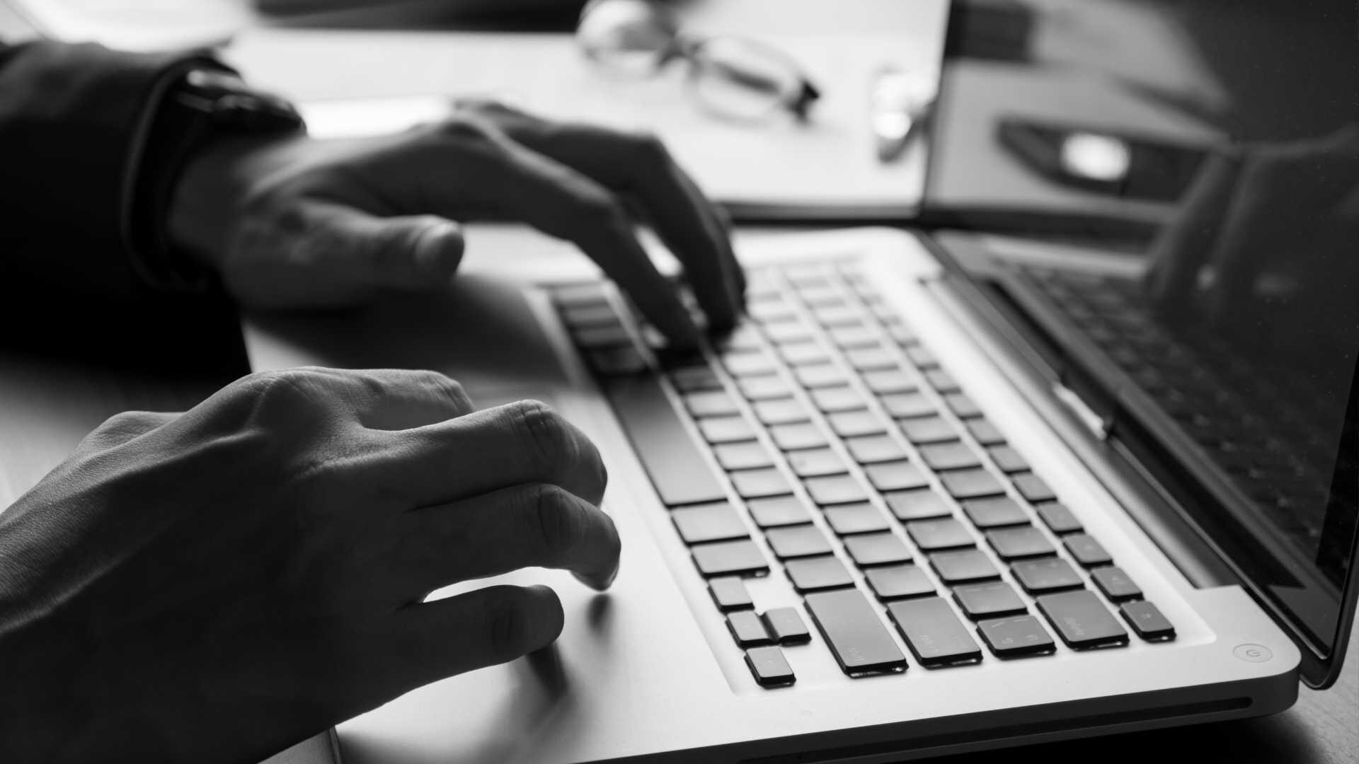 Close up of businessman using laptop on the office desk. Black and White tone