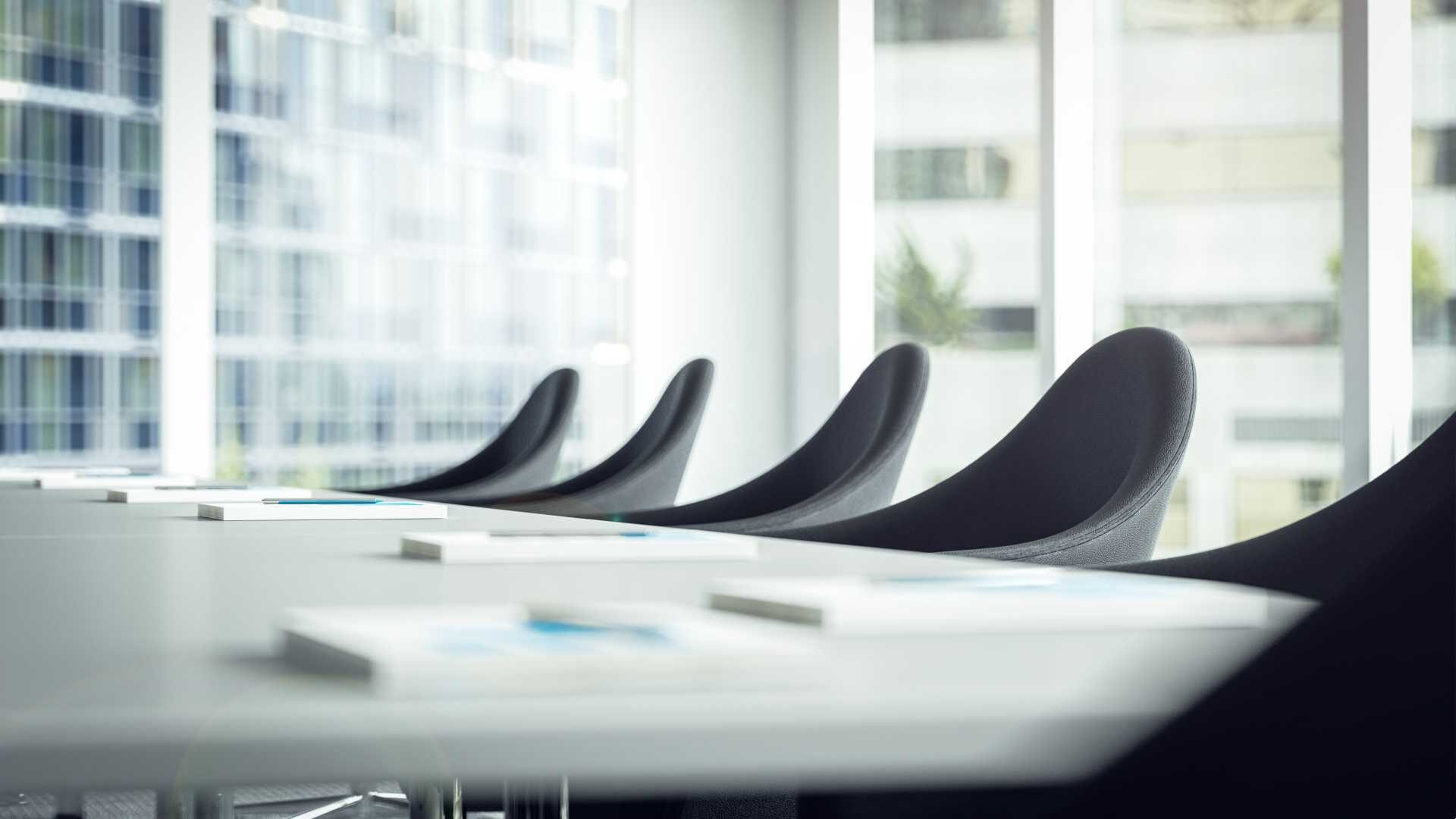 Empty chairs are pictured at a conference table