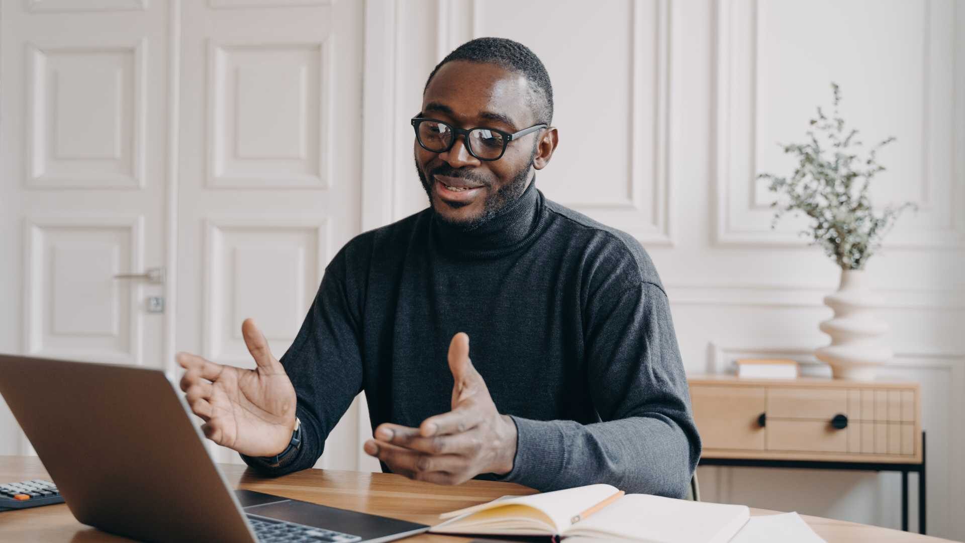 Man with glasses engaging in a video conference on his laptop in a peaceful at home office.