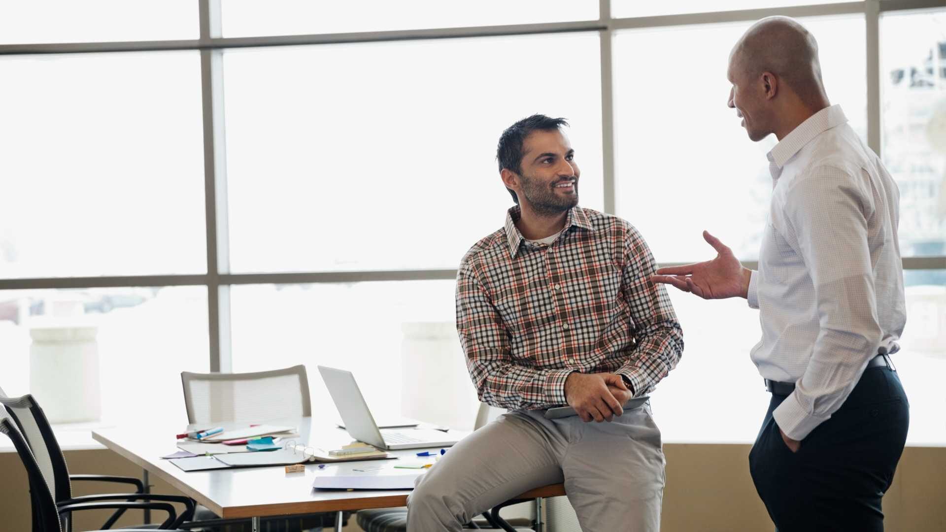 Two businessmen have a positive conversation in a workplace setting