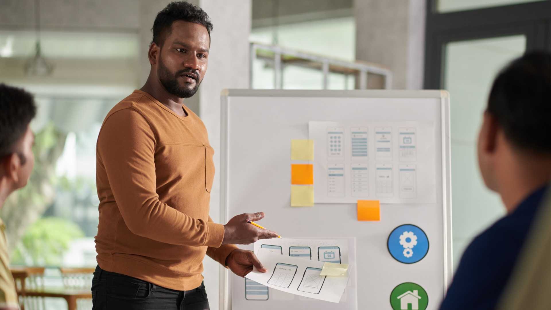 Training designer discussing his ideas with colleagues in meeting