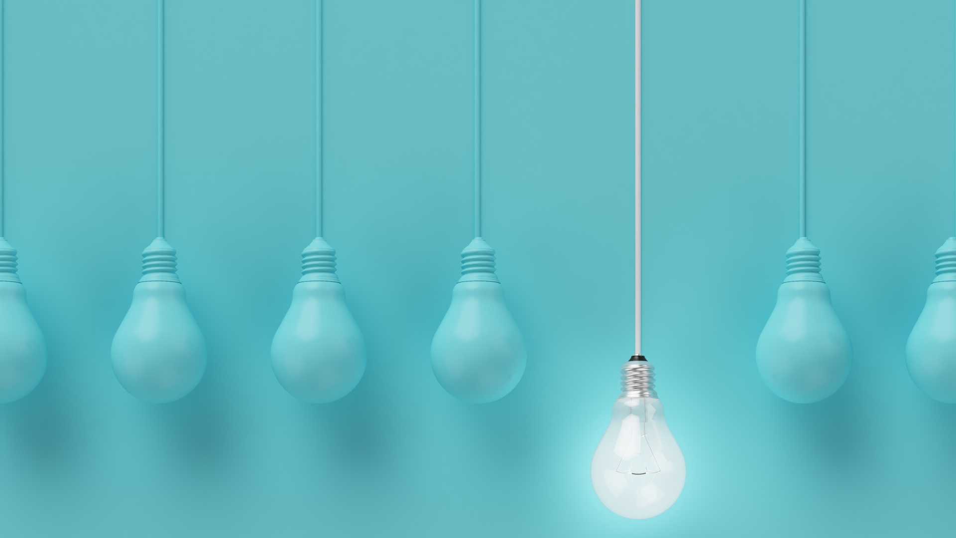 Hanging light bulbs with glowing one different idea on light blue background , Minimal concept idea , flat lay , top