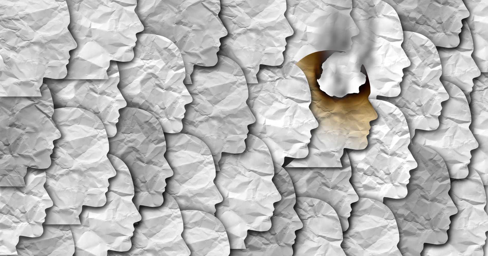 A repeating pattern of crumpled paper silhouettes of human heads. But one of them is singed, with a little smoke rising from it.