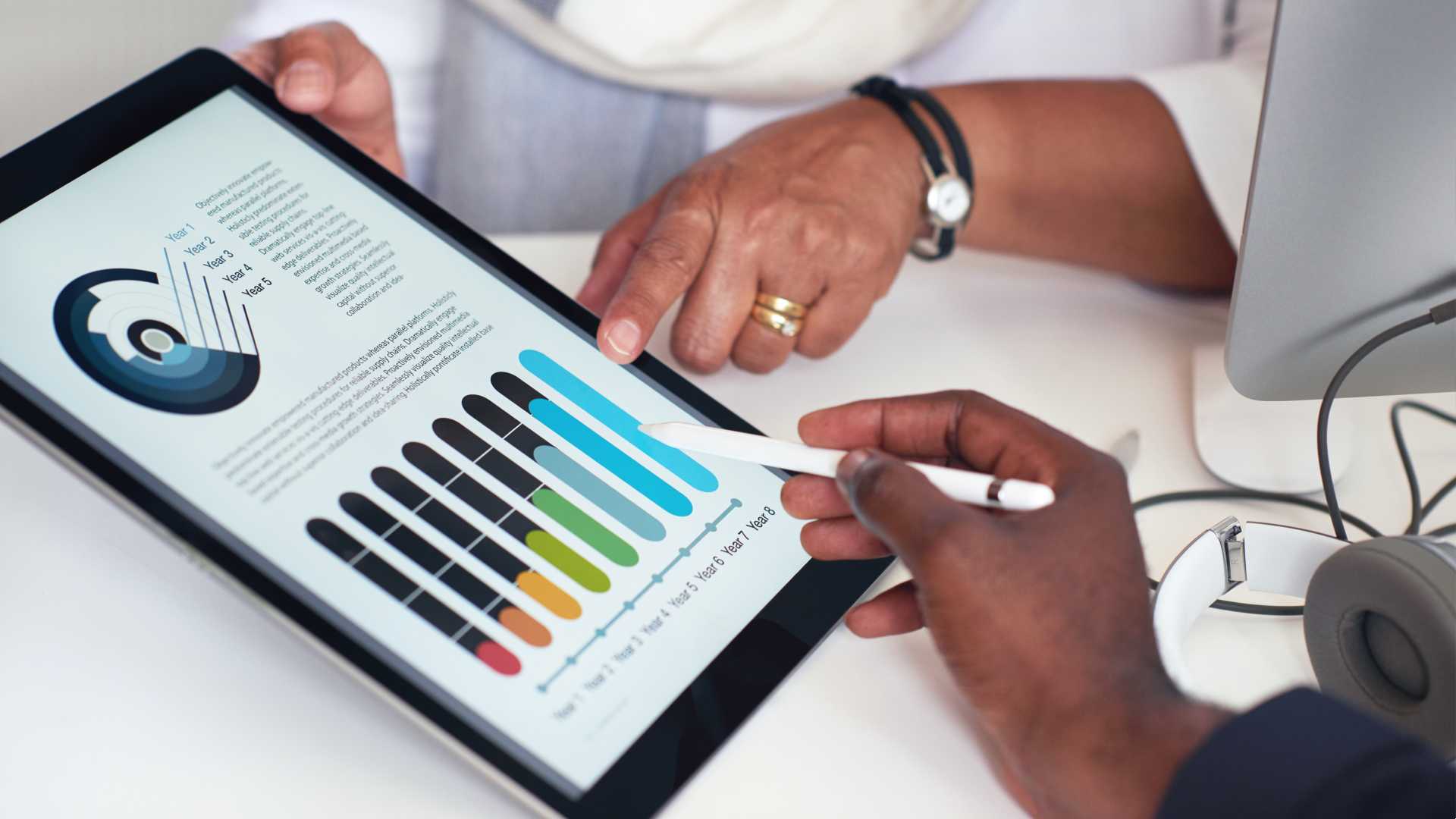 Business people's hands using digital tablet computer with data on screen