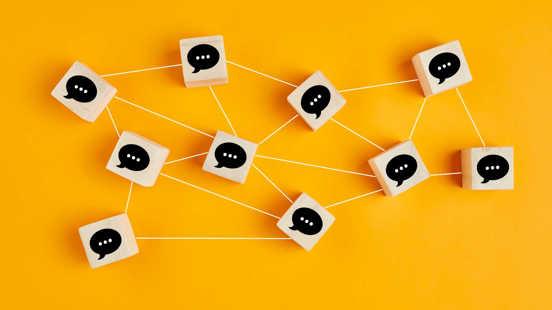 Concept of online communication or social networking. Wooden cubes with speech bubbles linked to each other with lines.