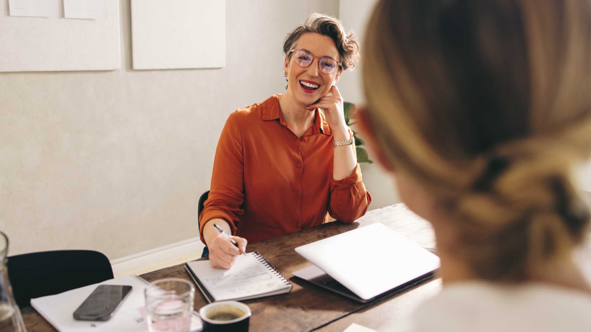 Cheerful business person having a meeting with a coworker or employee