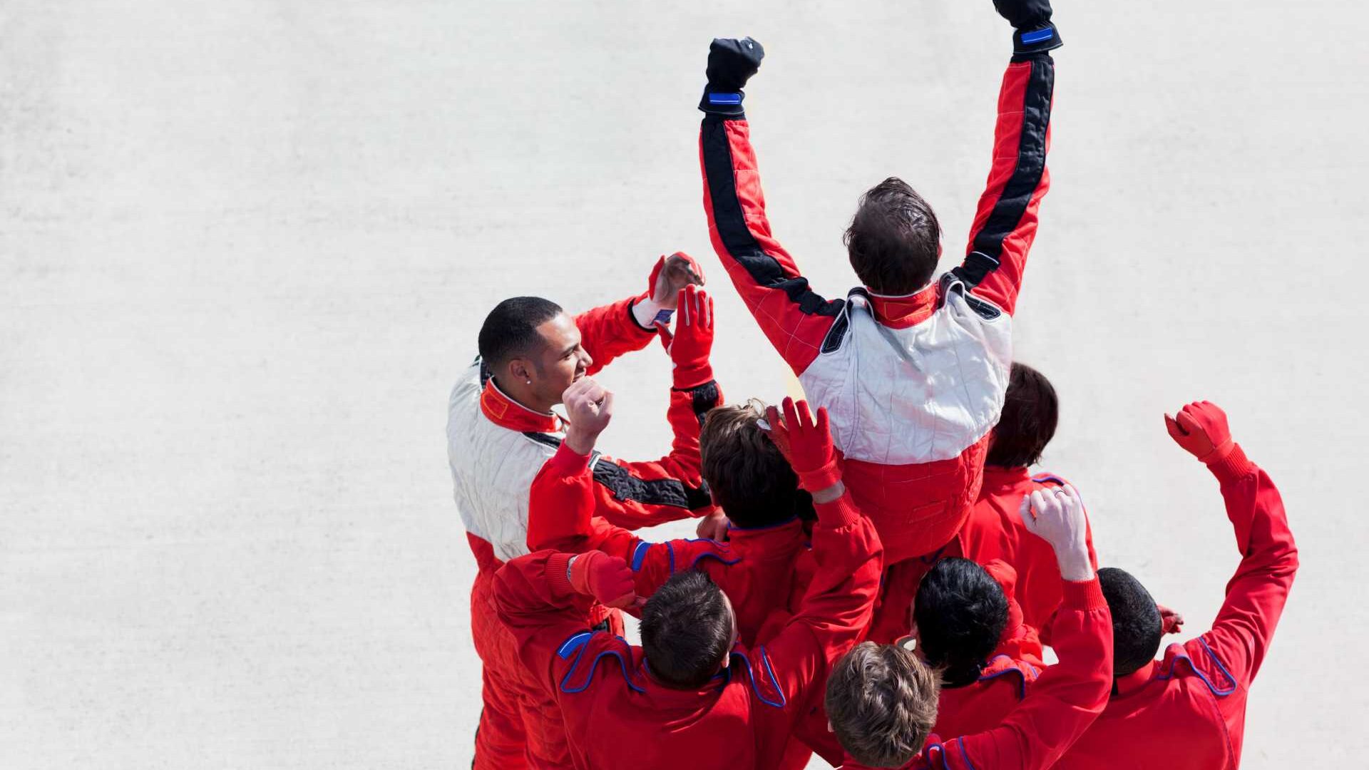 A team of racecar drivers celebrates a win
