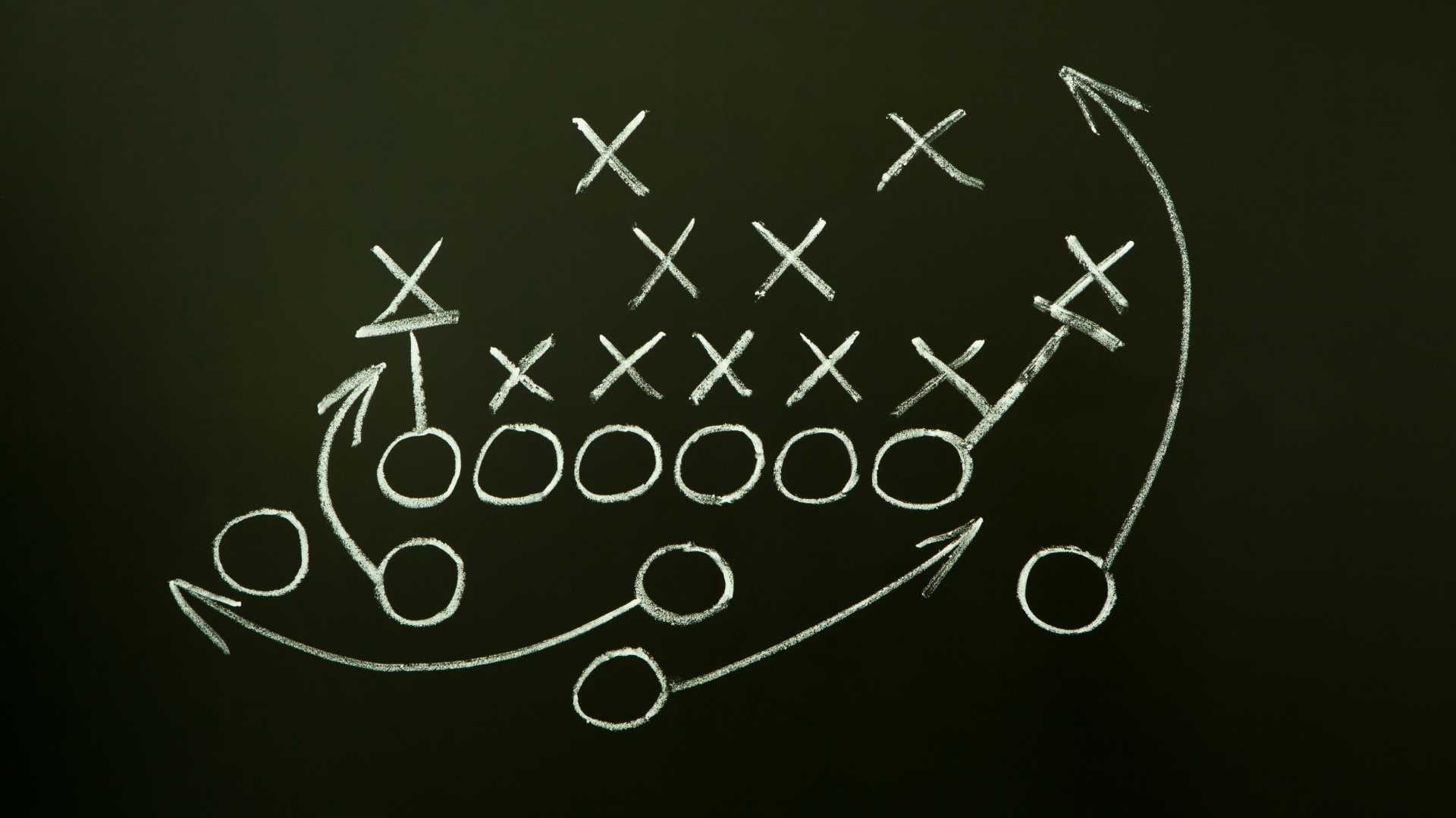 Game strategy drawn with white chalk on a blackboard.