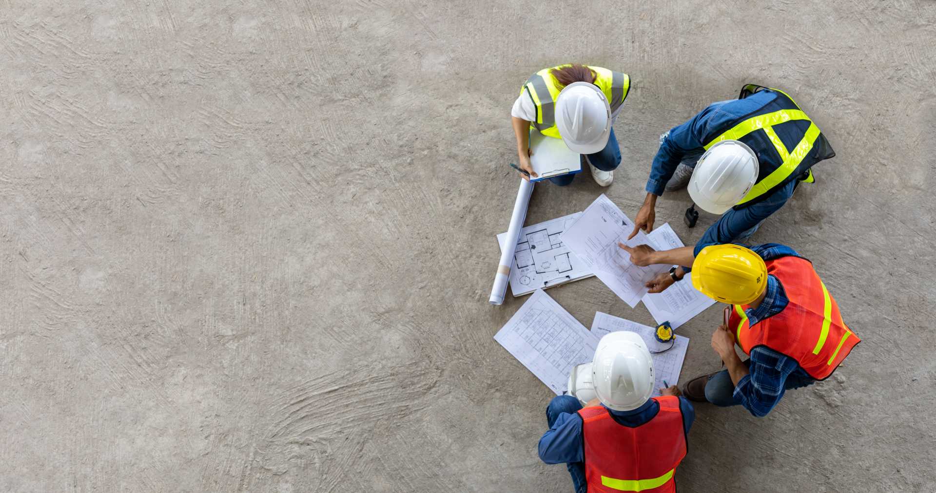 Manufacturing workers huddled around blueprint for work.