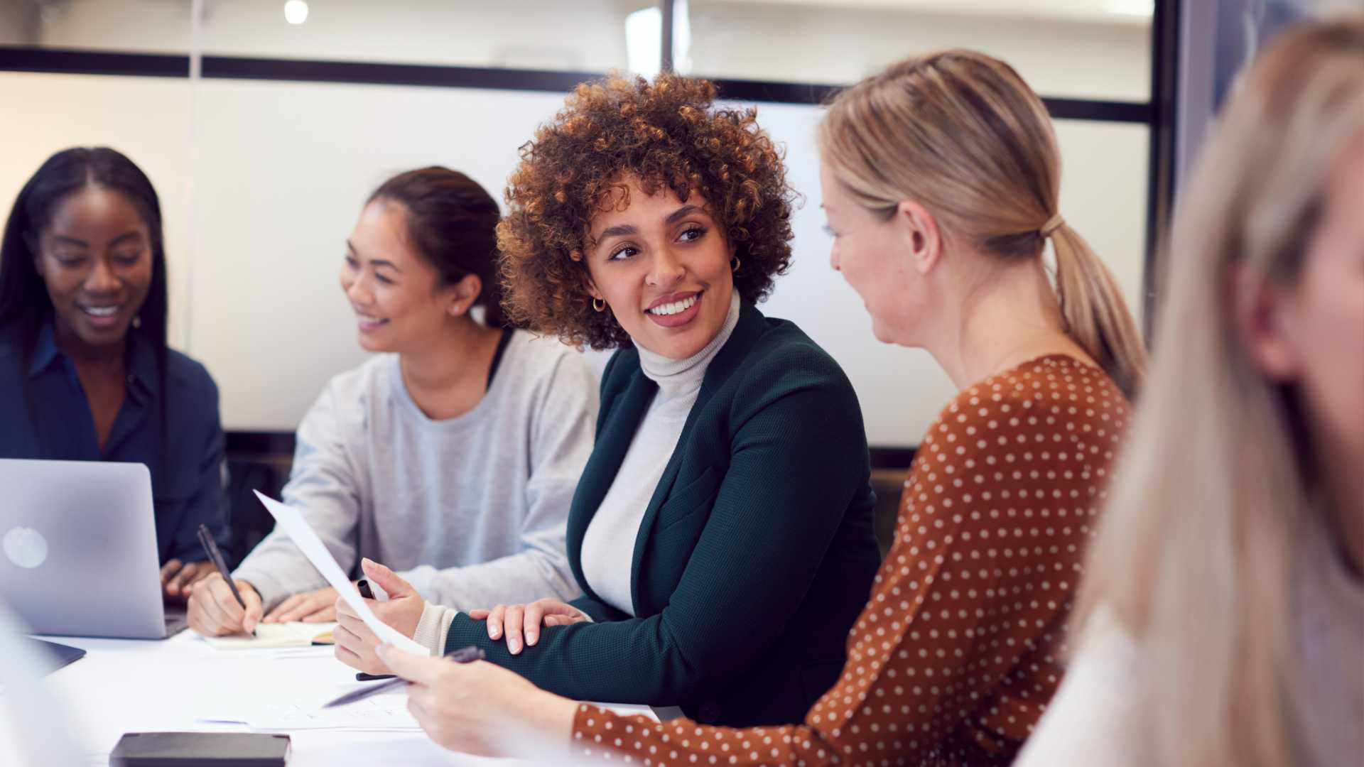 A table of Gen Z workers engaging in team collaboration and communication in the workplace.