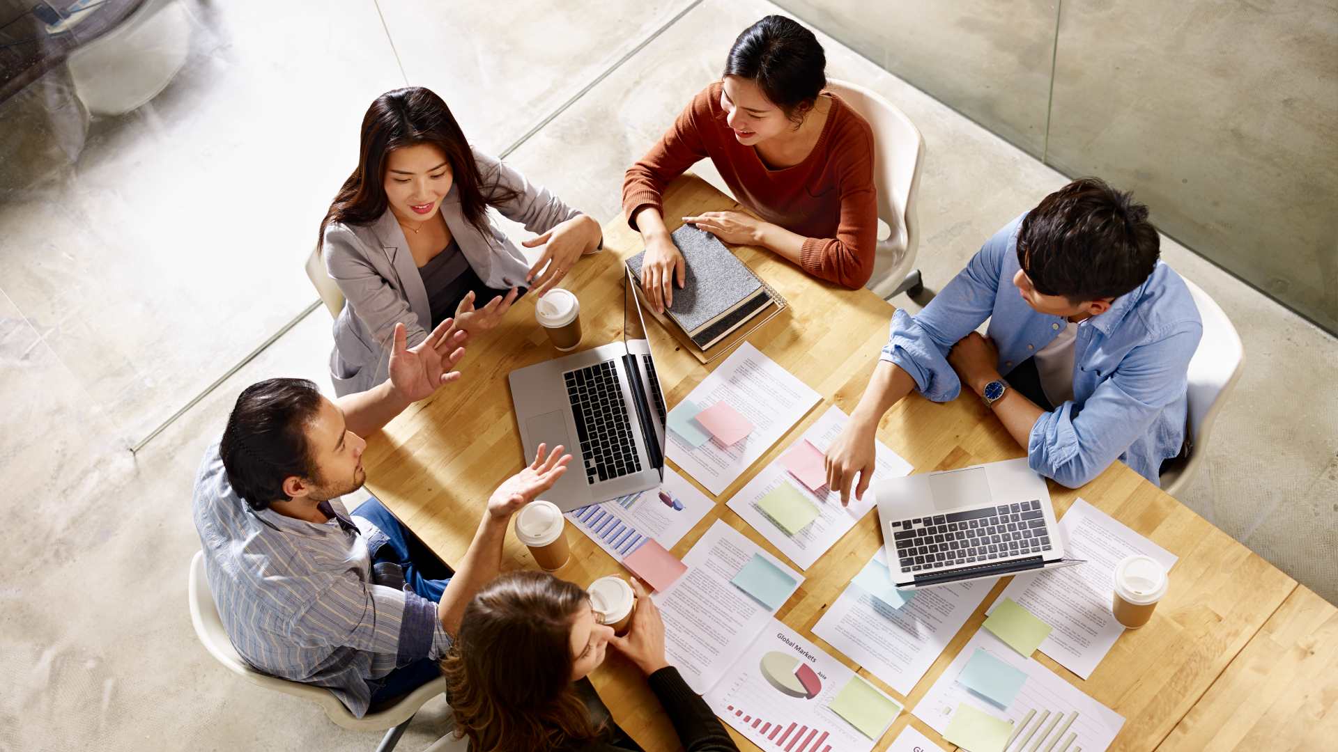high angle view of a team of coworkers discussing business in meeting room.