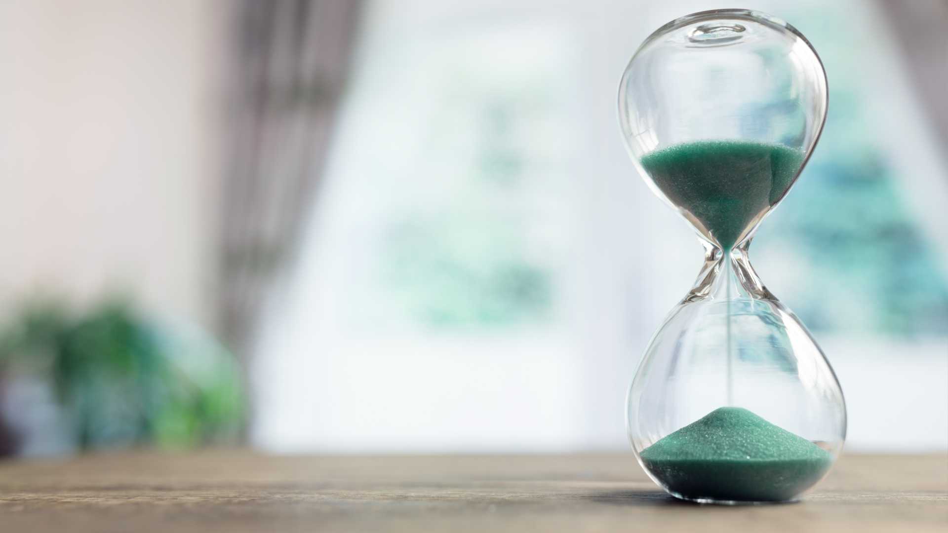 hourglass time passing on table in room by window