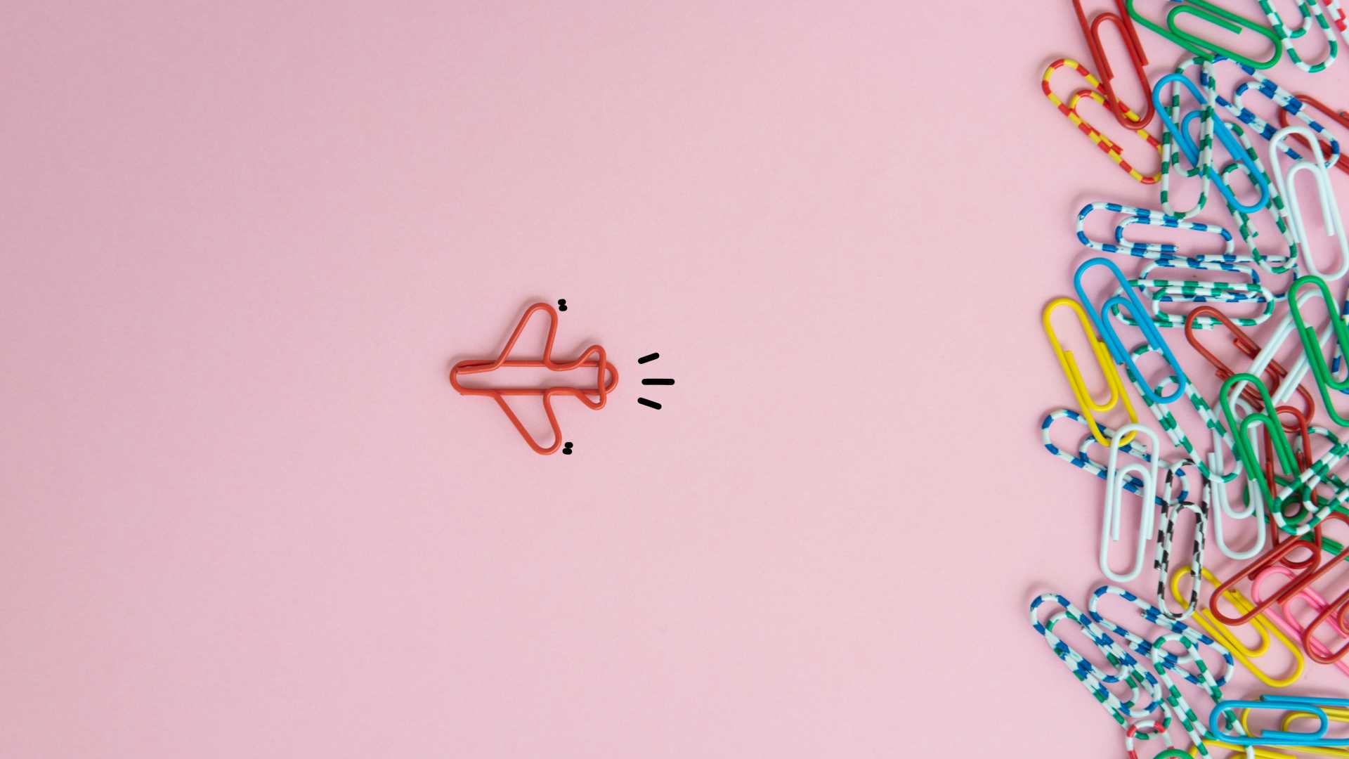 Animation of paperclips and a red airplane made of red paperclips flying away against a pink background.