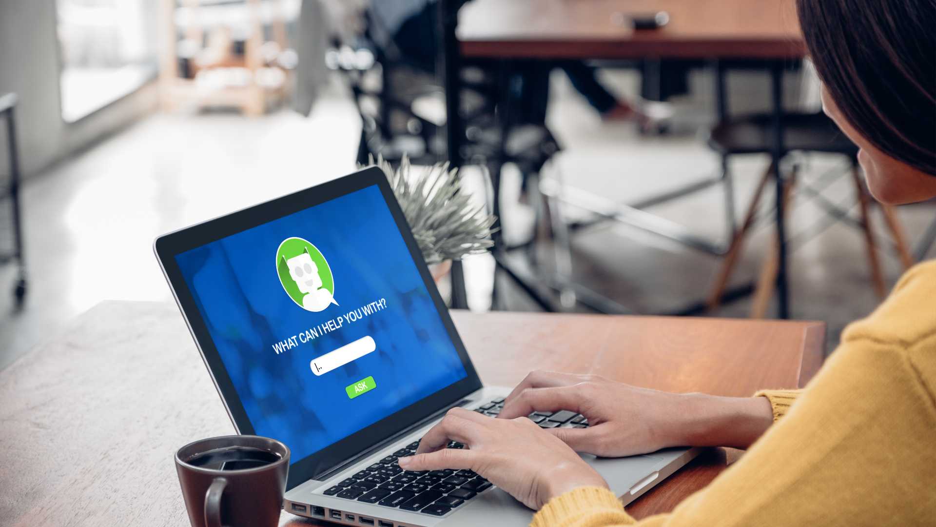 person sitting at a laptop with chat bot function on screen