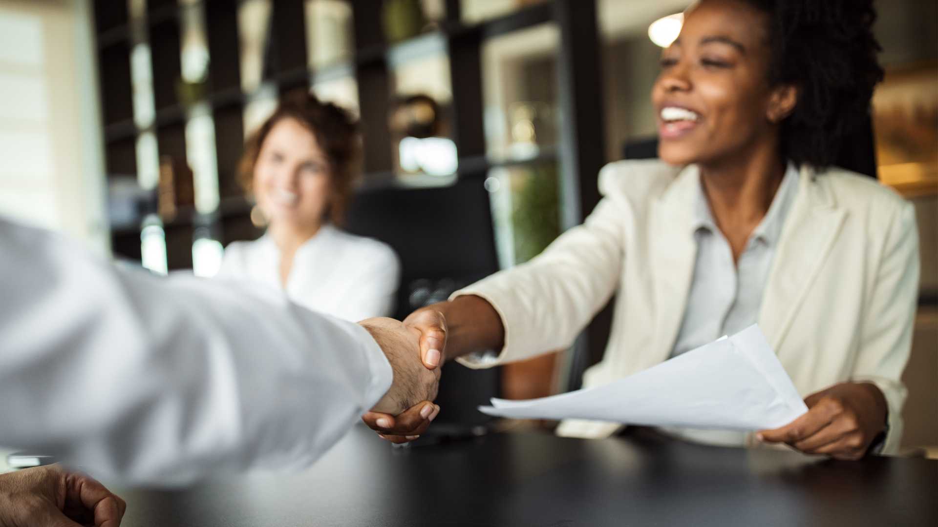 business woman shaking hands with someone in a meeting