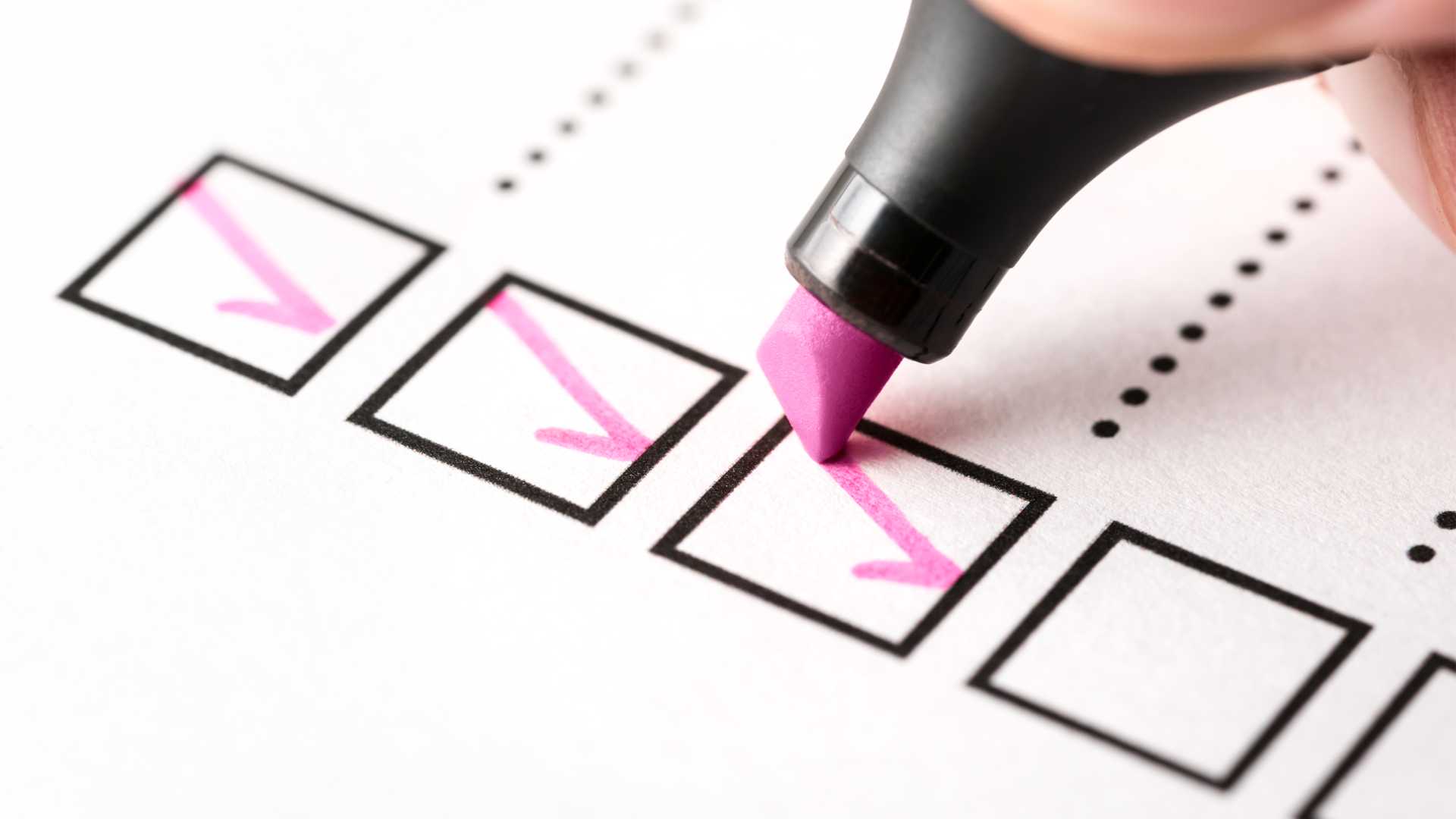 Pink highlighter marker checking off a list for onboarding new hires in an organization.