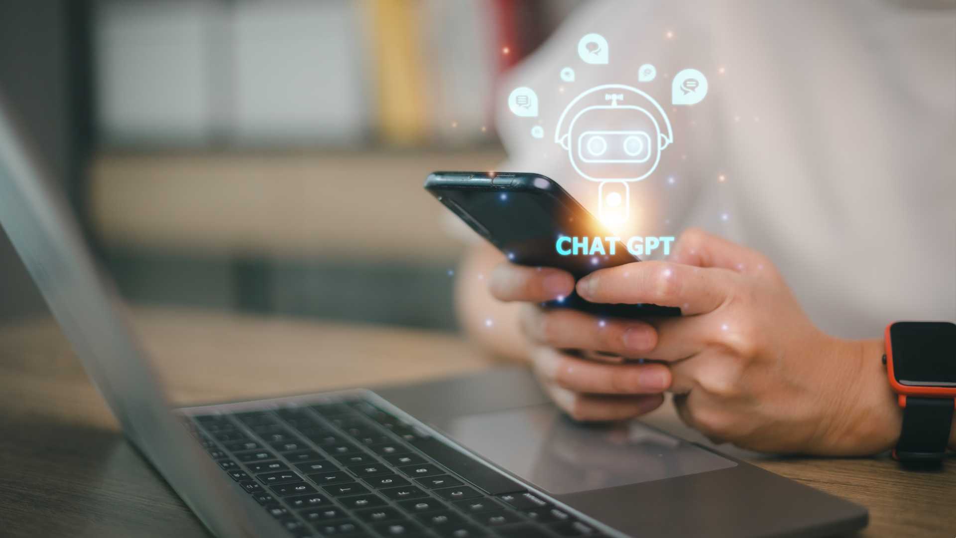 Person utilizing generative artificial intelligence (AI) on their mobile device and laptop for efficient team and organizational dynamics.