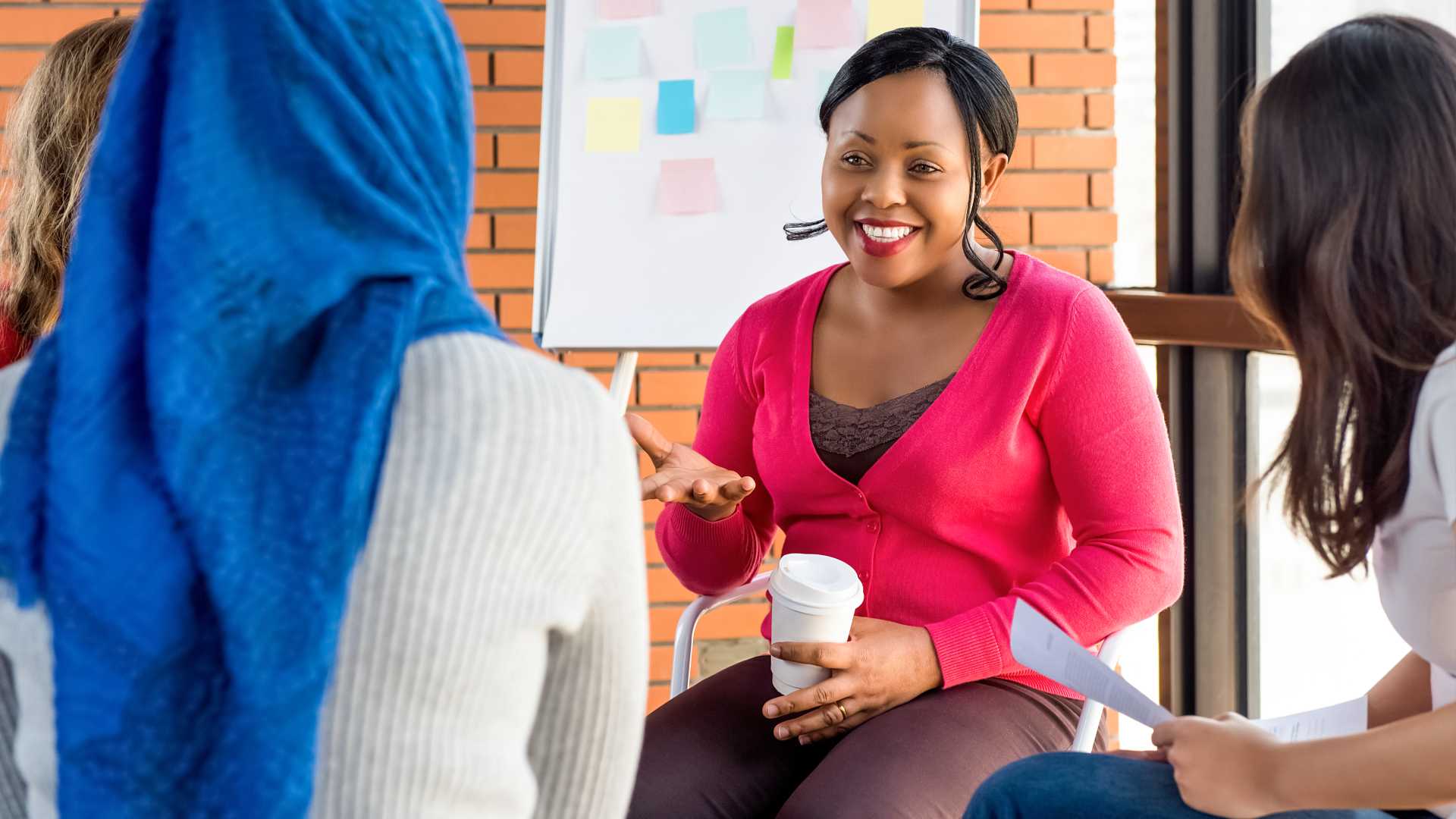 Diverse group of women in colorful clothes at the meeting, discussing project