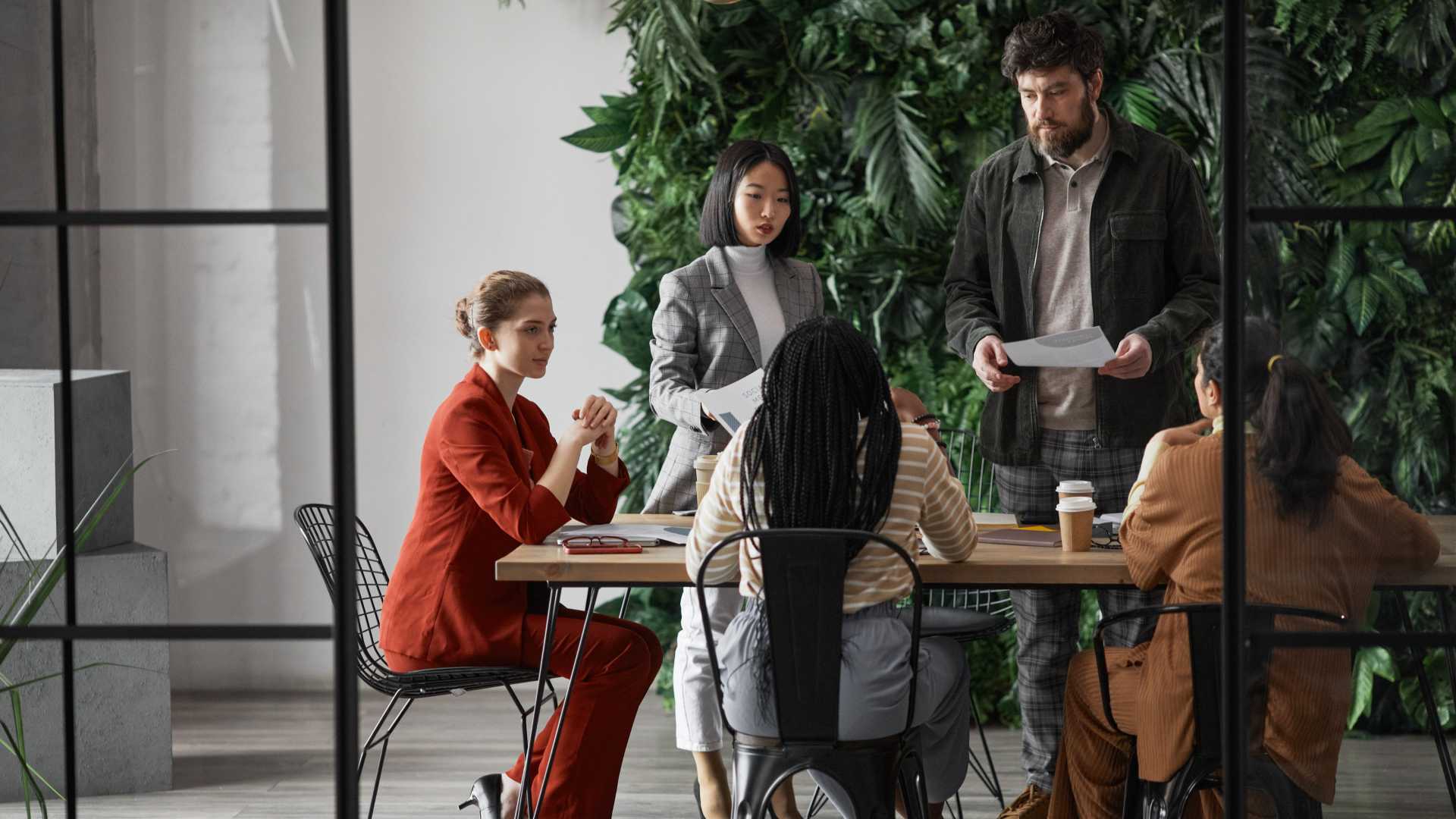 A group of businesspeople collaborate around a table in an open office space