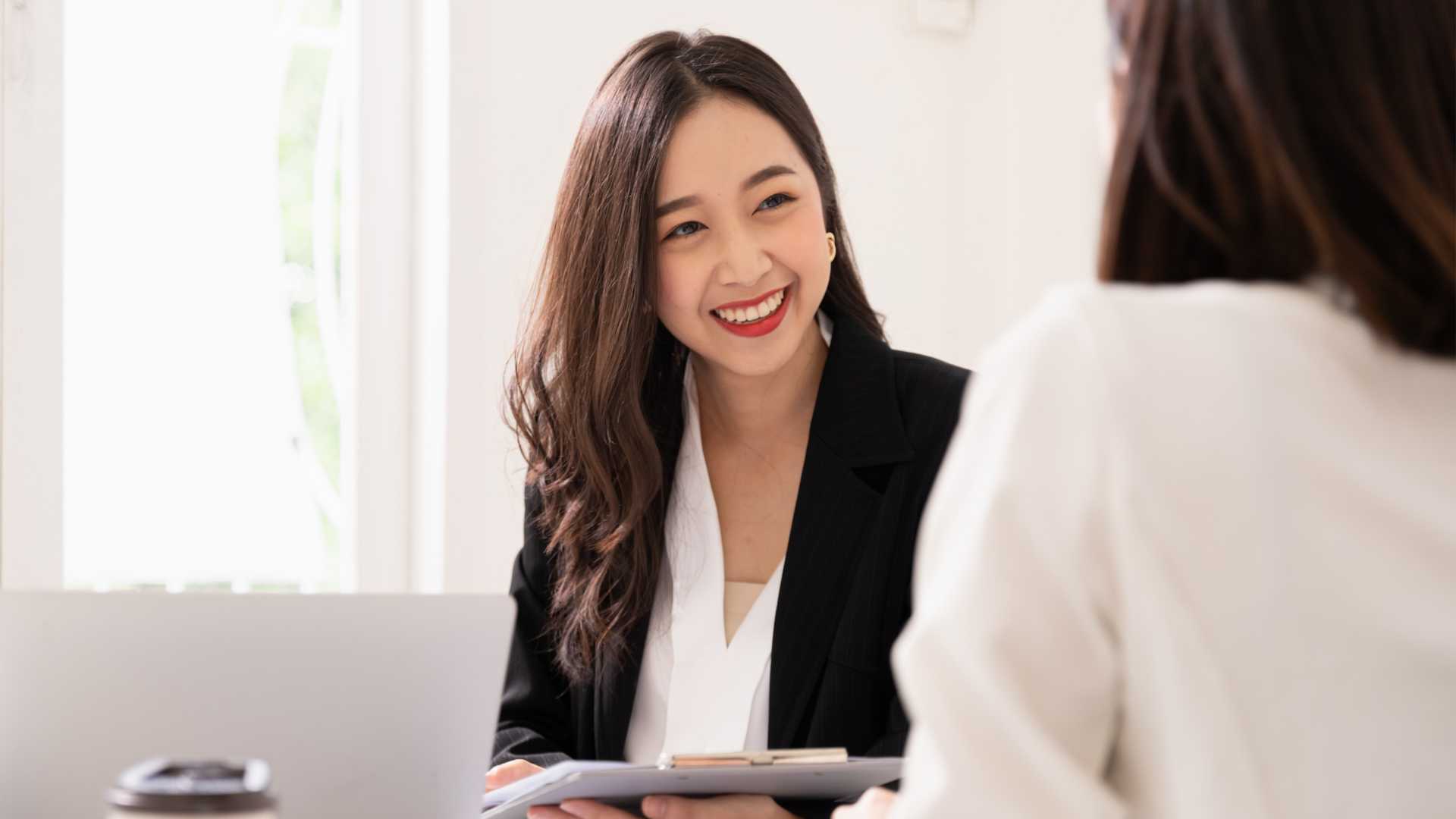 A businesswoman conducts a feedback session with an executive leader