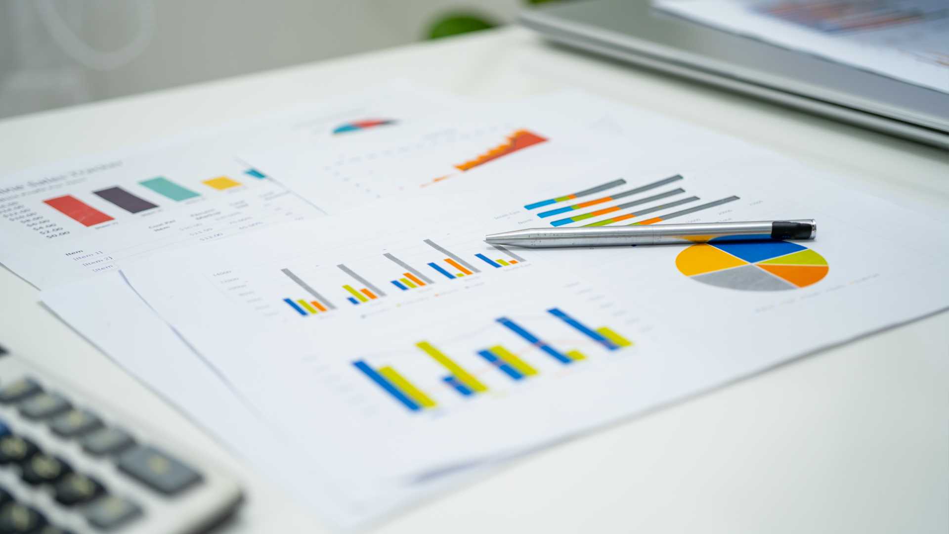 A desktop with printed graphs displaying training ROI.