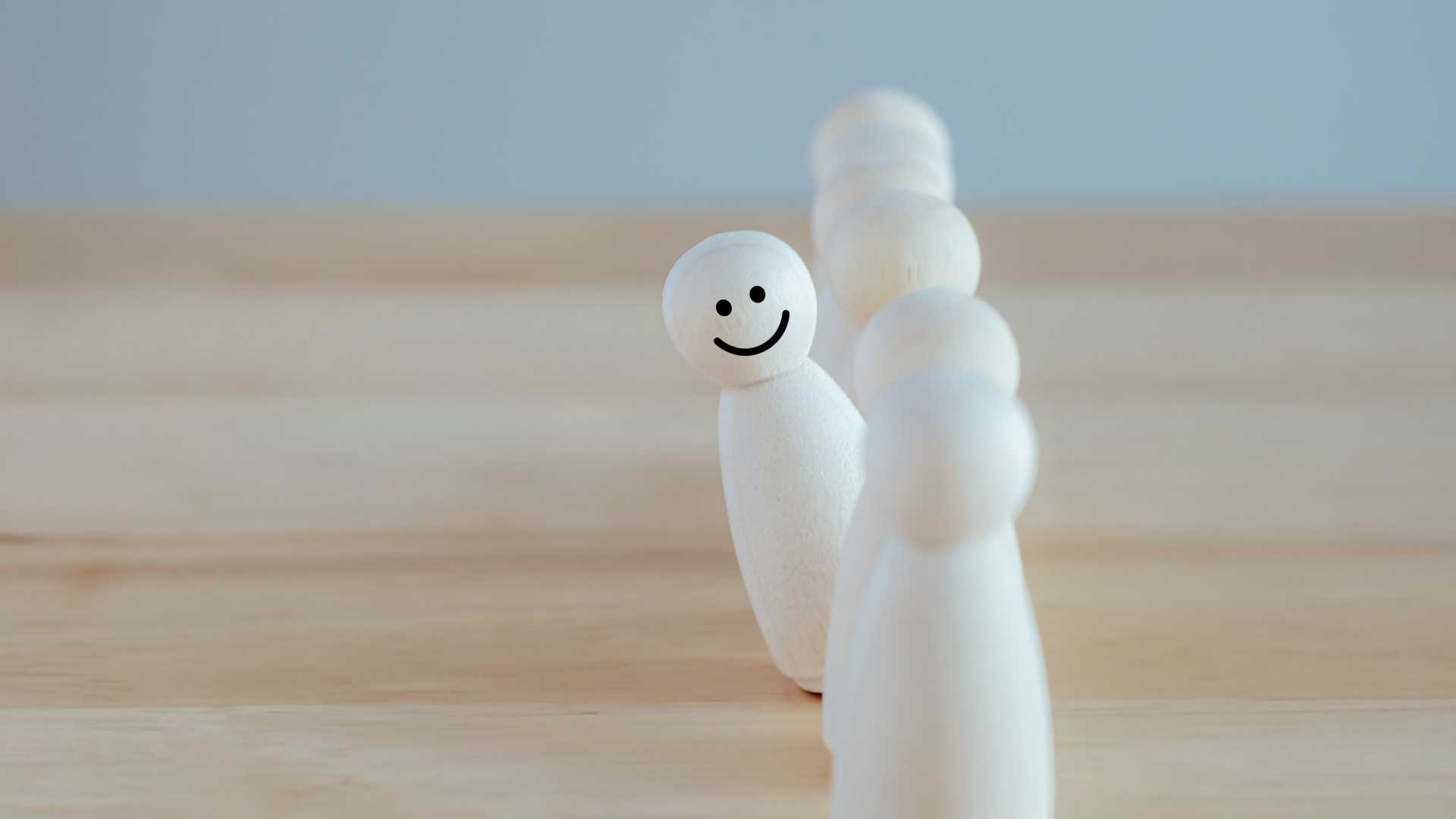 A line of wooden figures carved in the shape of what is intended to represent people; skilled trades workers lined up ready to meet the demand.