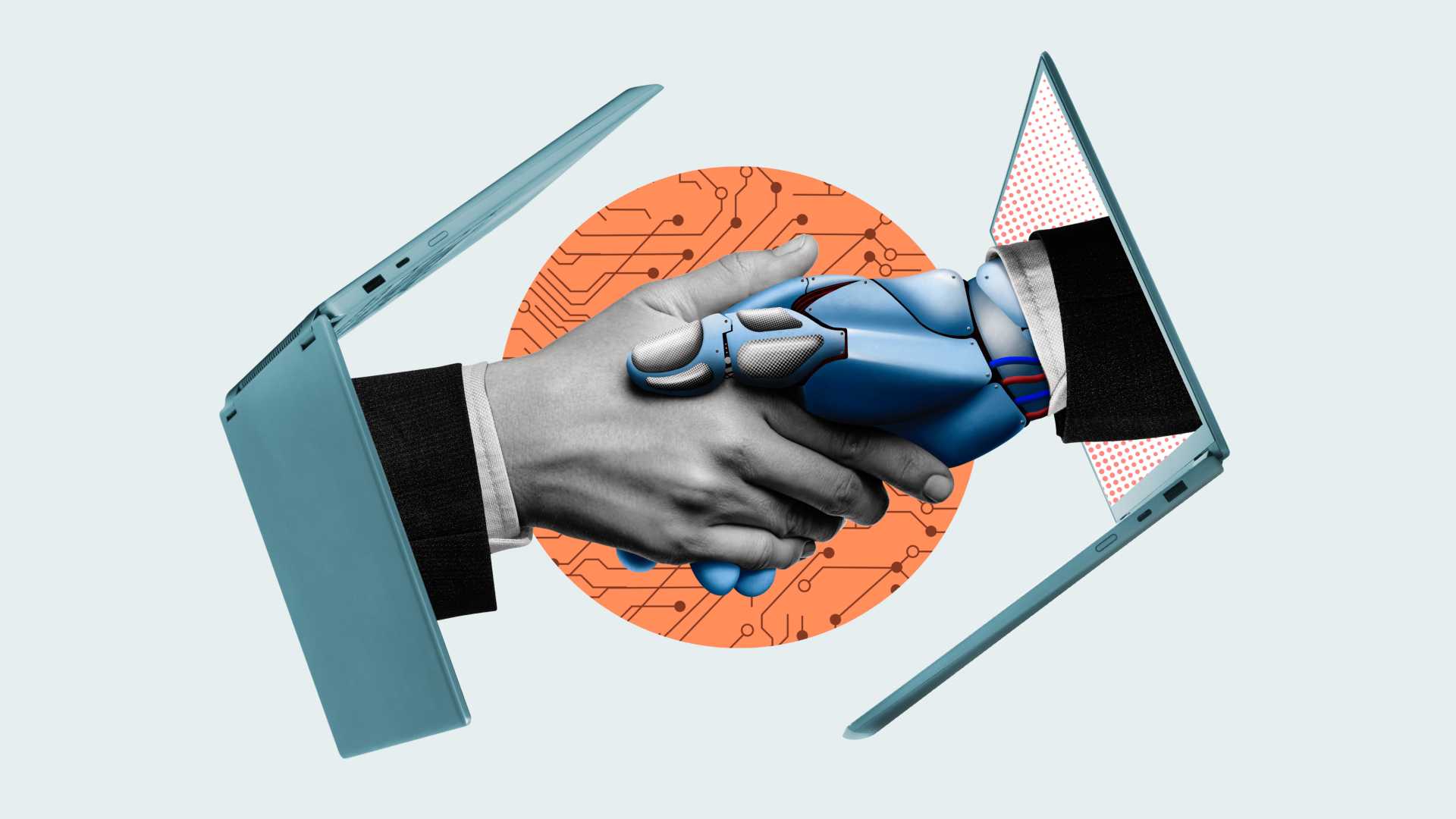 One laptop faces another with a human hand shaking an android hand