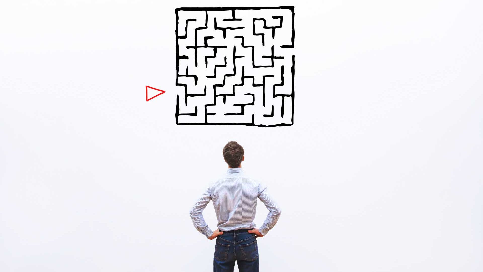 A man is looking at maze graph trying to figure out his next move