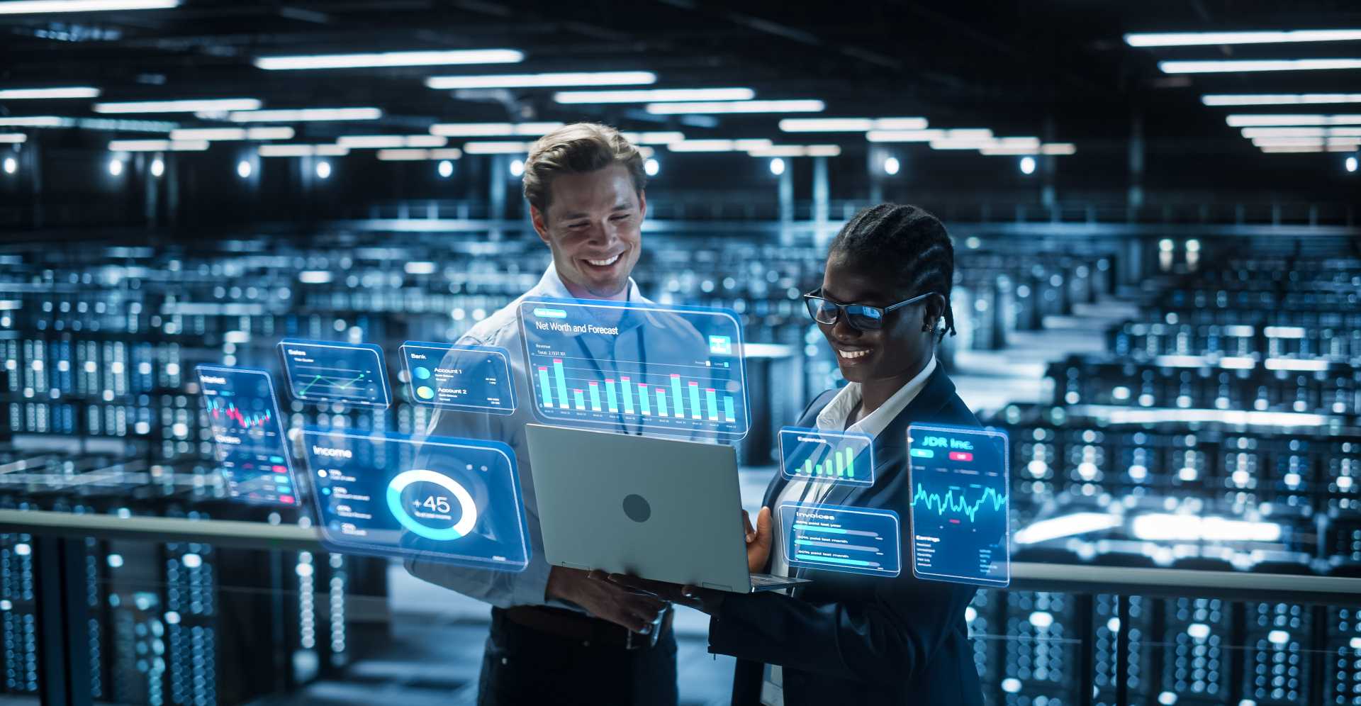A man and woman are looking at a computer screen with digital artwork around it.