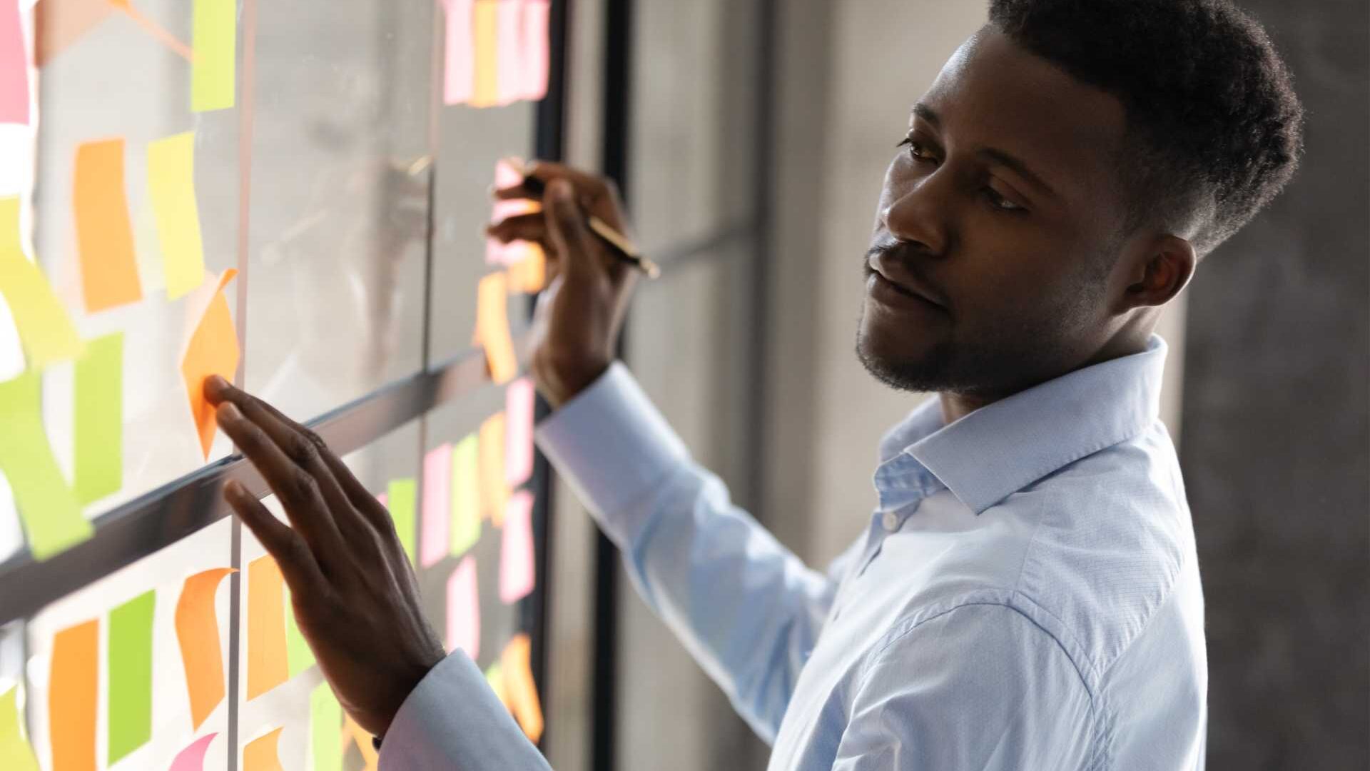 Man planning on something by looking at sticky notes