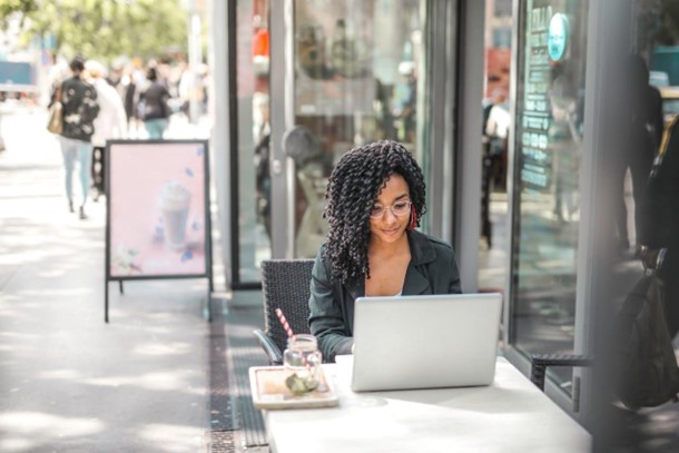 Woman sitting down and using her laptop doing work