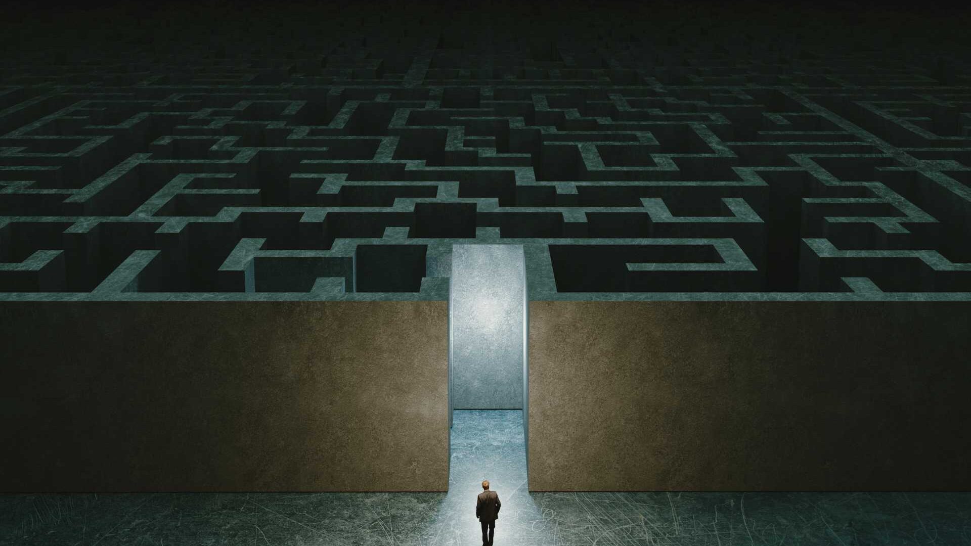 businessman standing in front of the entrance to the maze