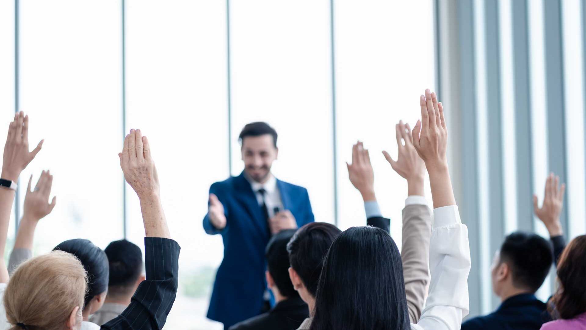 Man giving a presentation in front a crowd of people .