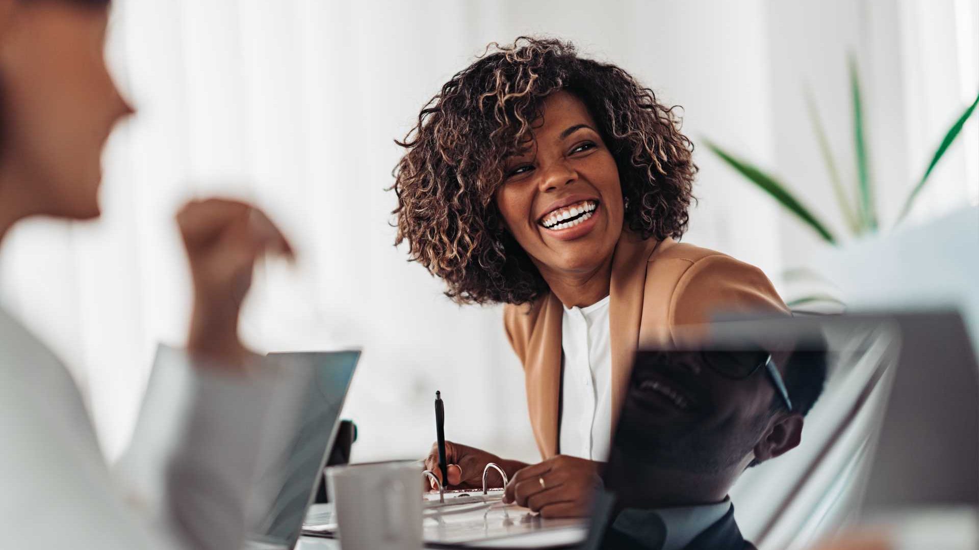 Woman smiling with her team discussing work.