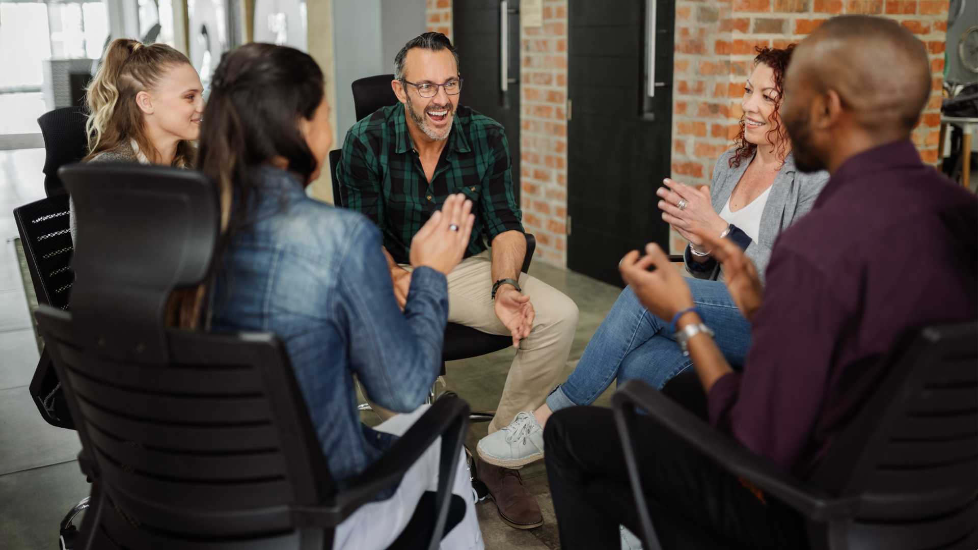 Group of people meeting together and sitting together in gathering.