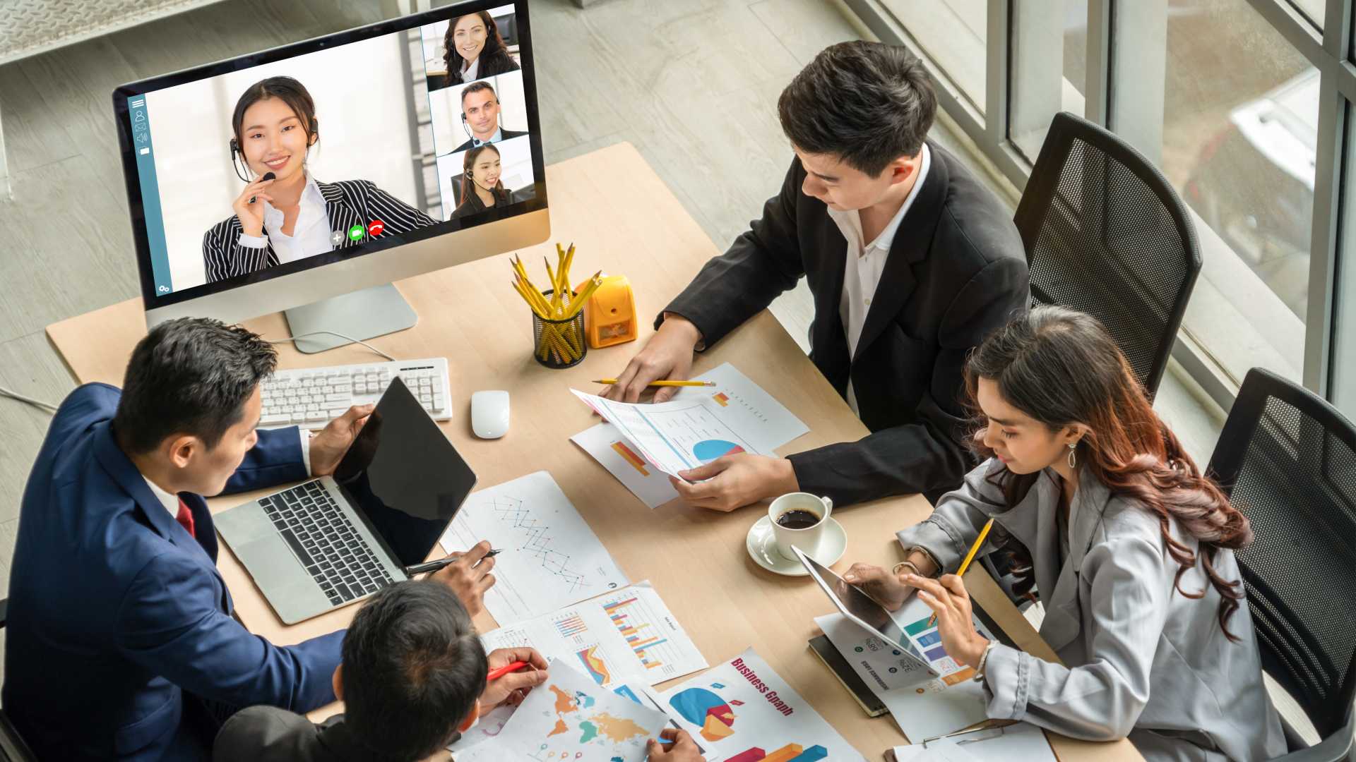 People in a team meeting those who are remotely joining on in a video call.
