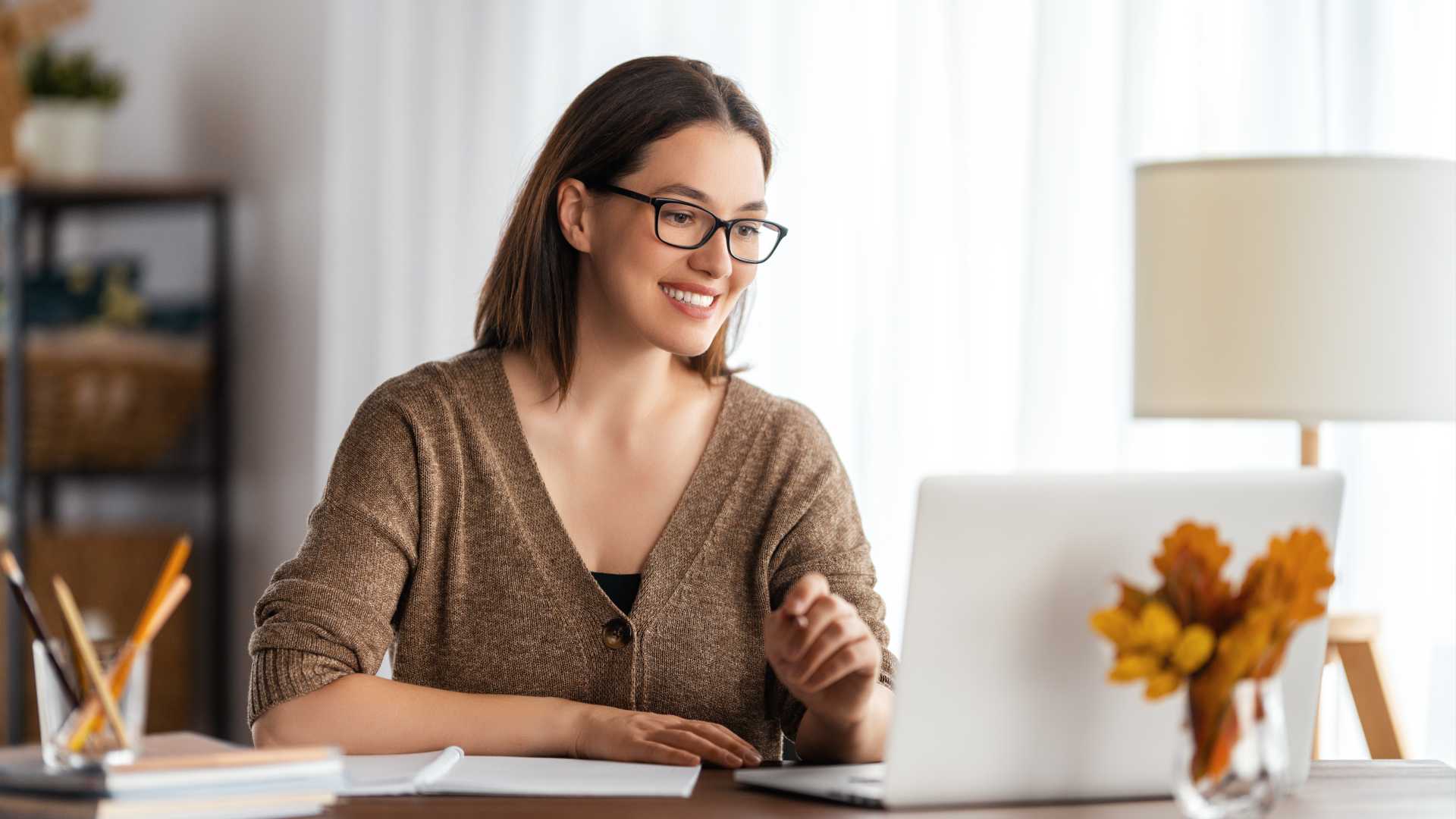 Woman looking at her laptop and working remotely at home.
